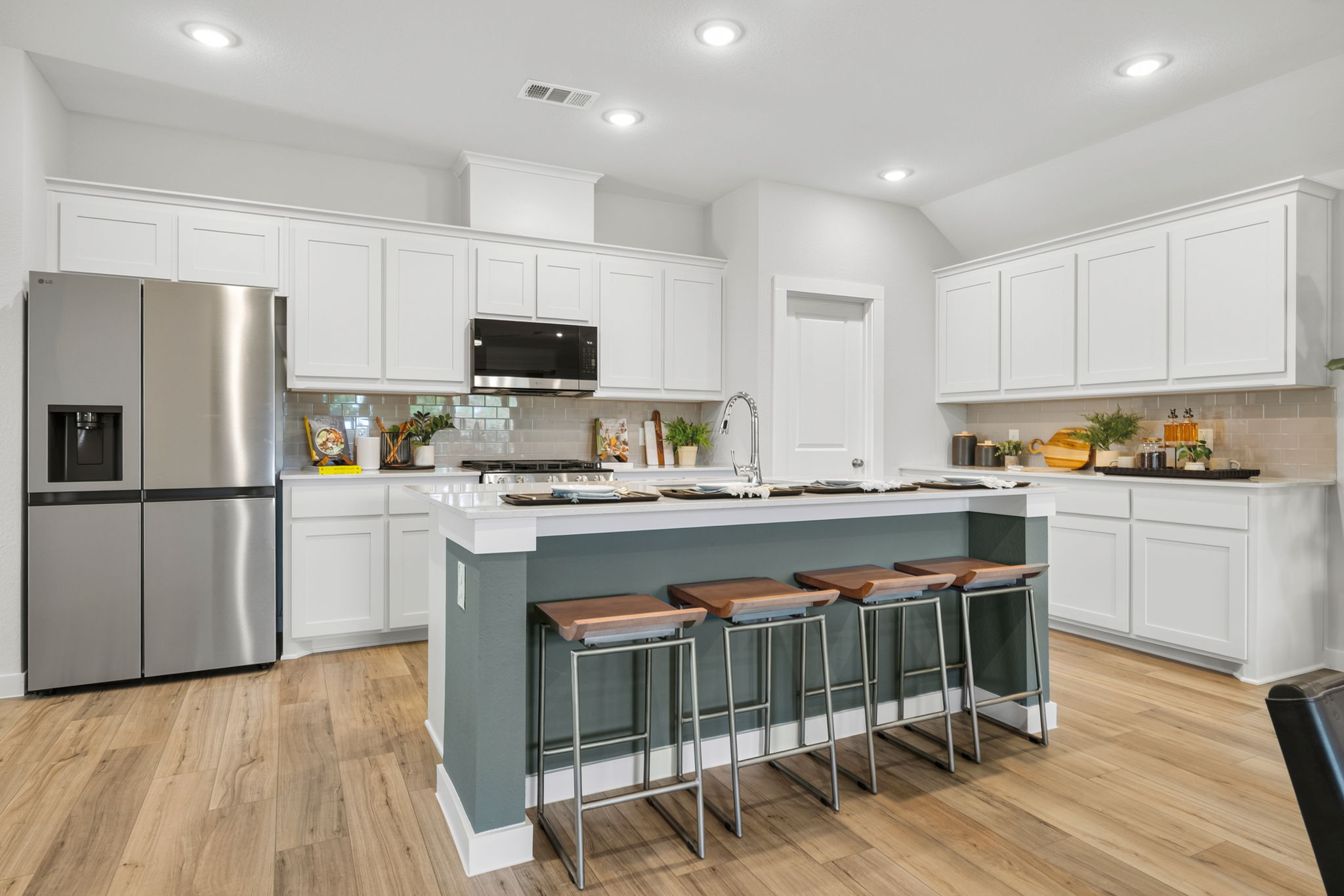 A kitchen with white cabinets.