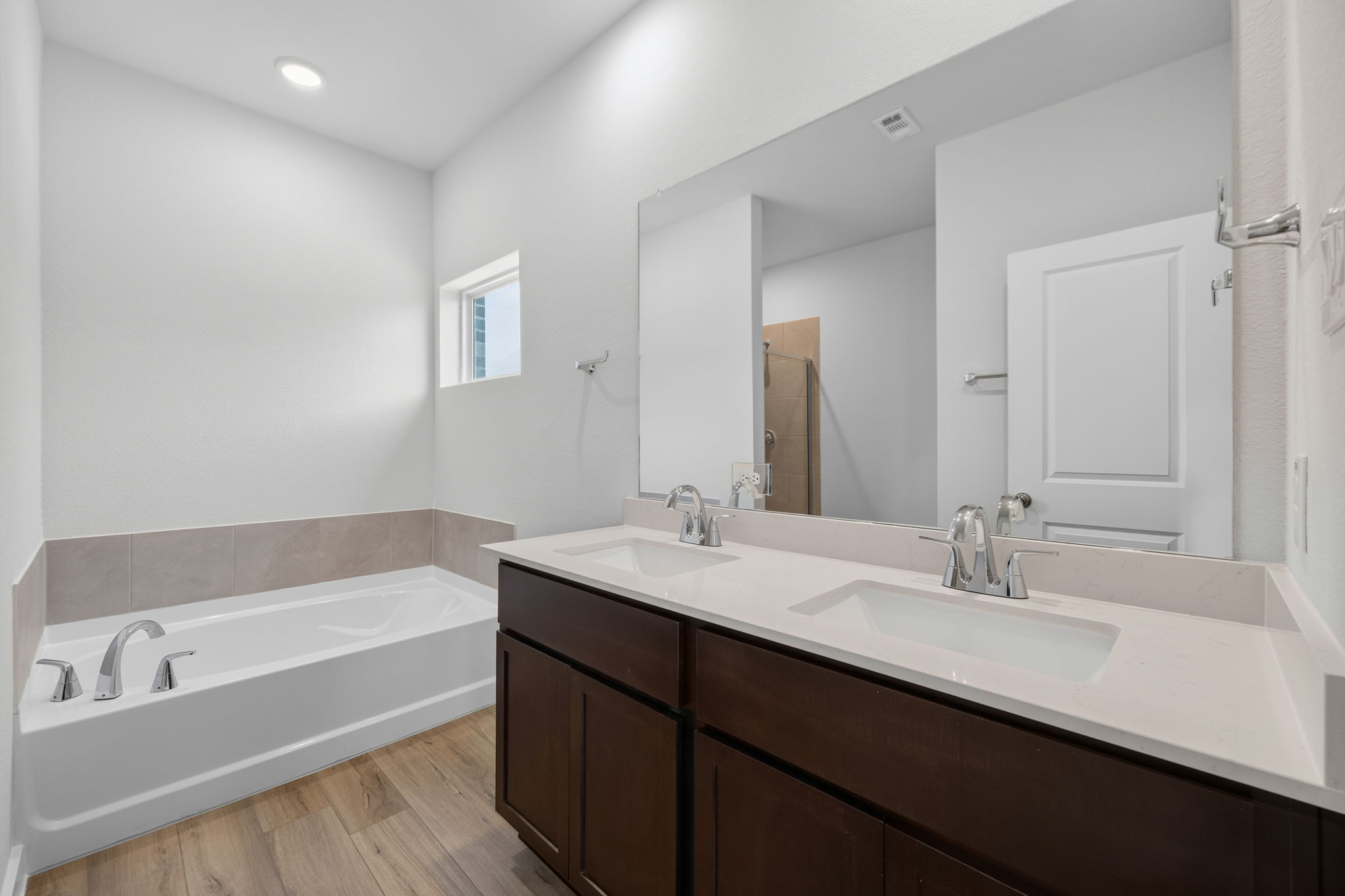 A bathroom with a tub sink and a mirror.