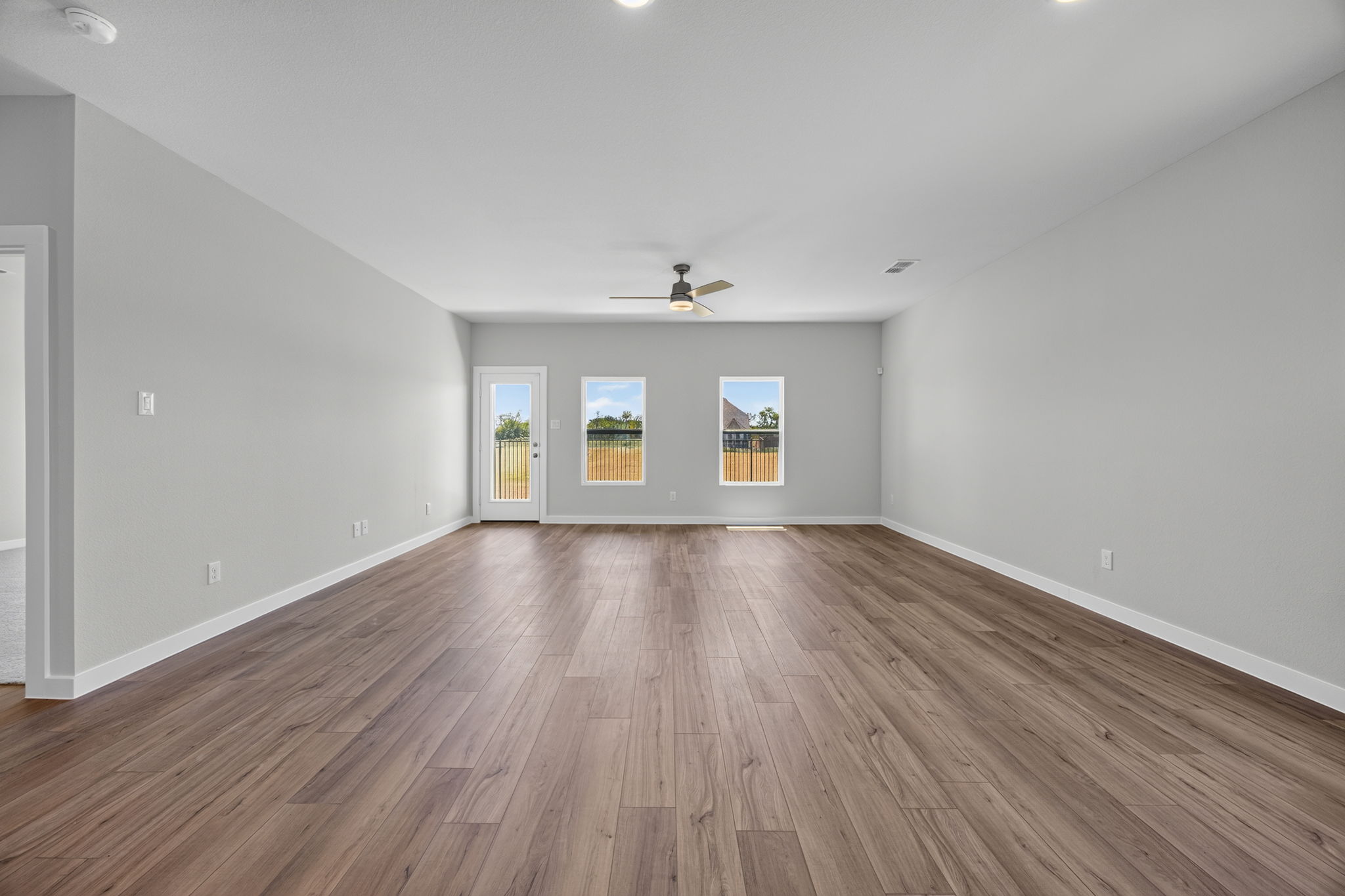 A room with a wood floor and a ceiling fan.