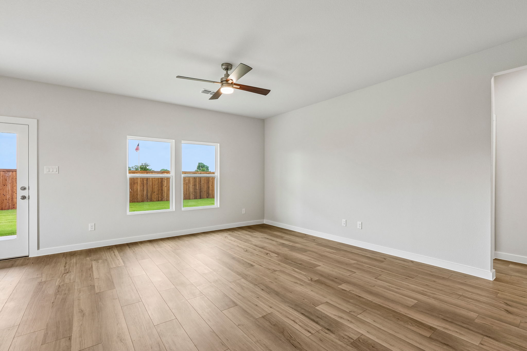 A room with a wood floor and a ceiling fan.
