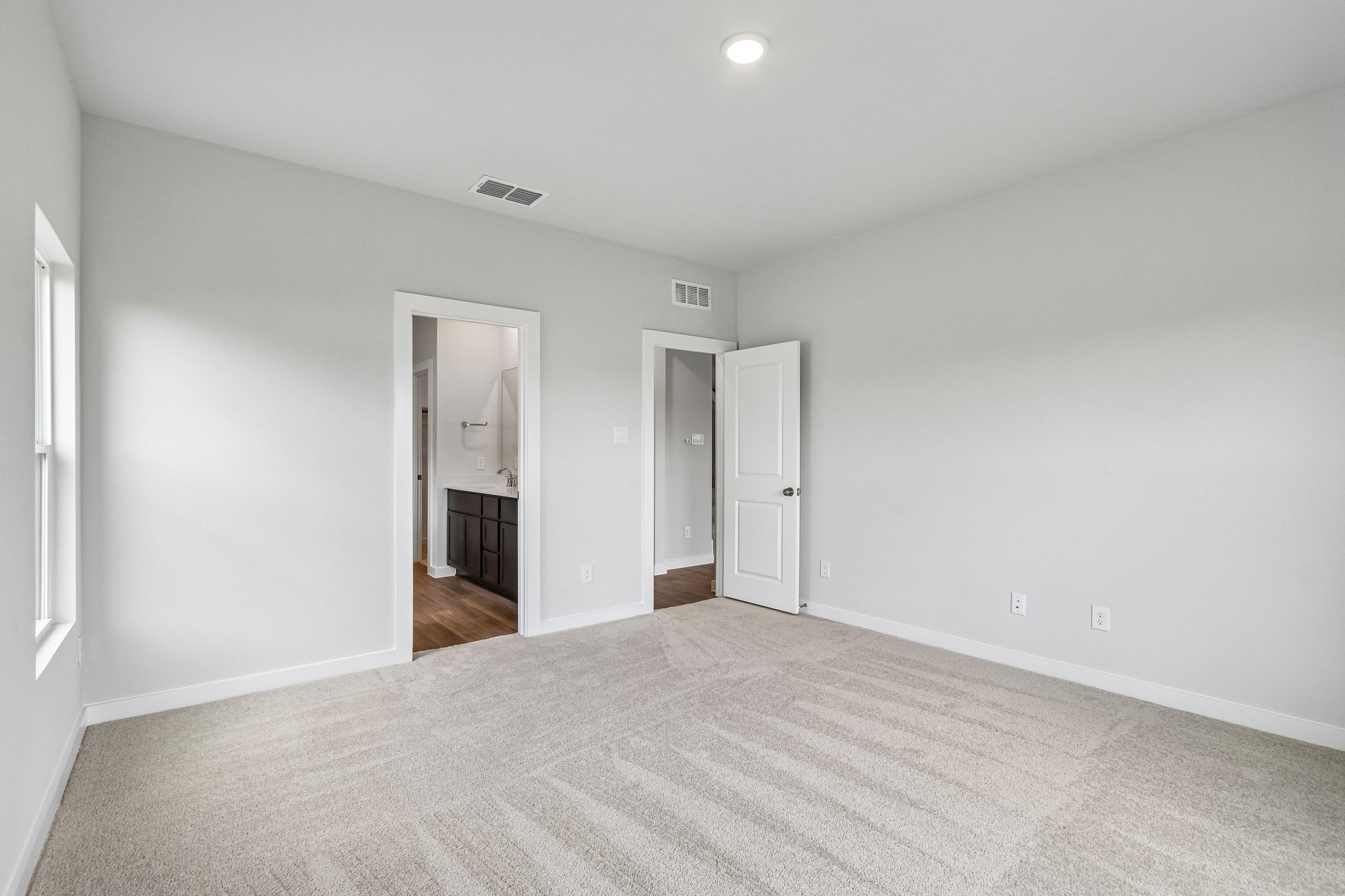 A room with a carpet and a door.