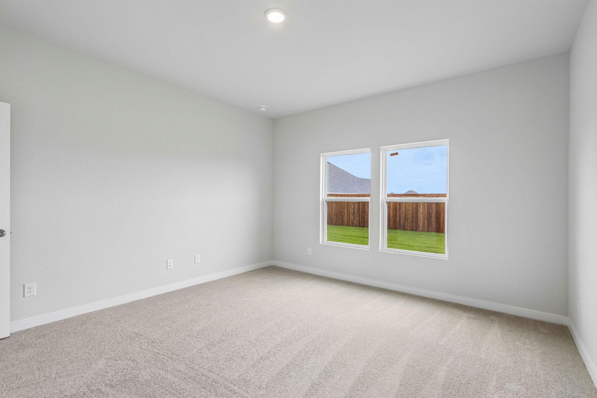 A room with a window and a carpet.