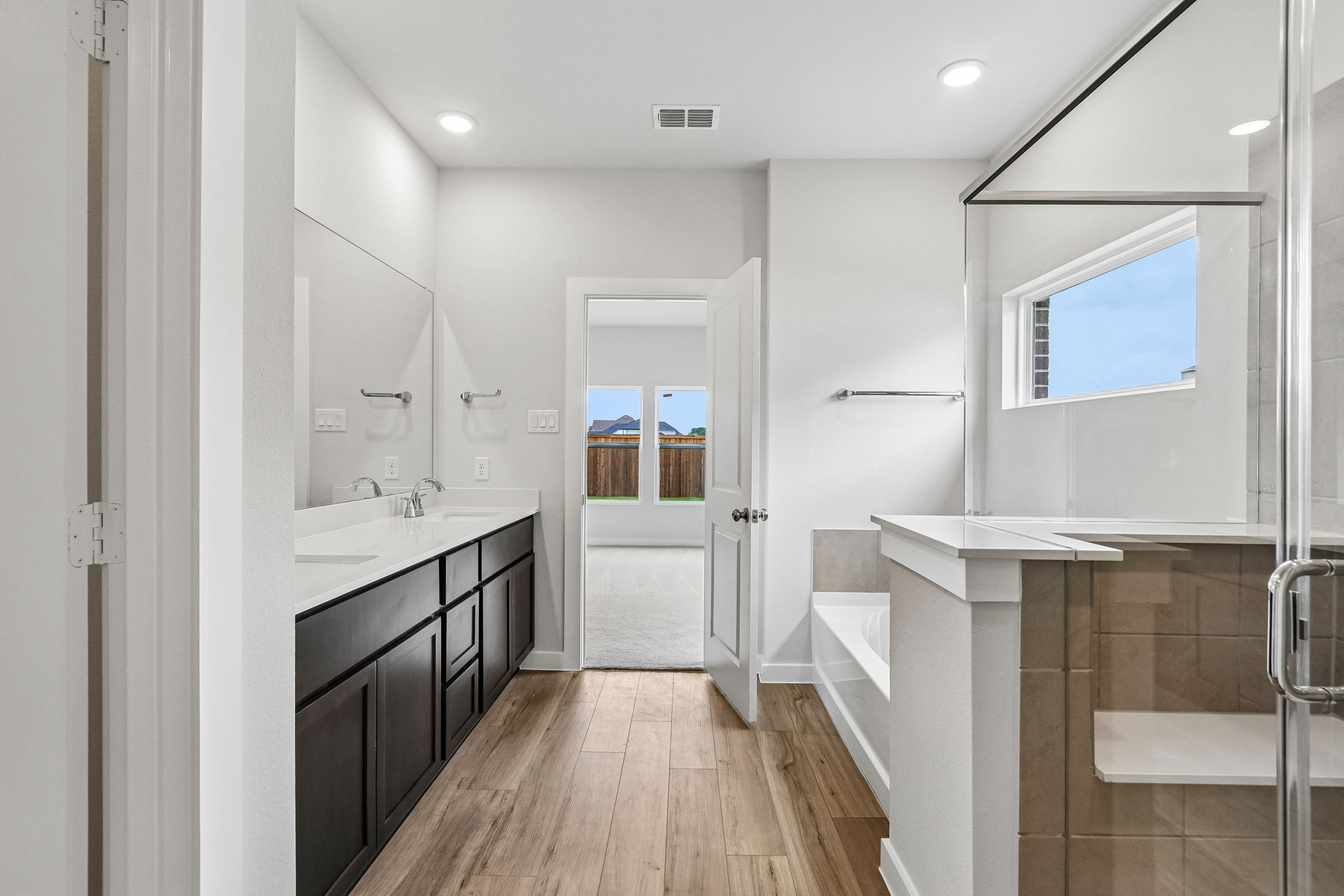 A bathroom with a tub sink and a mirror.