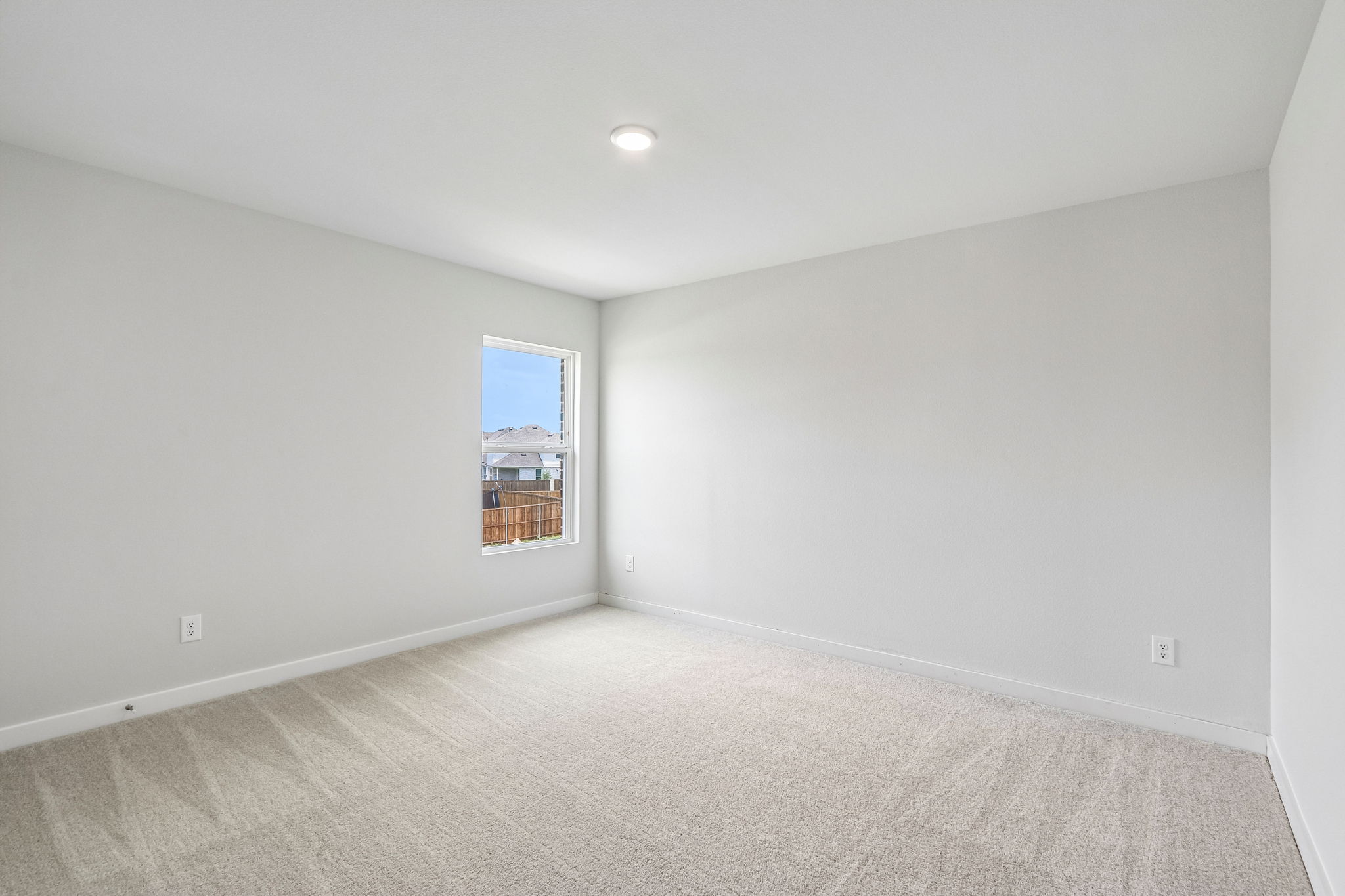 A room with a window and carpet.