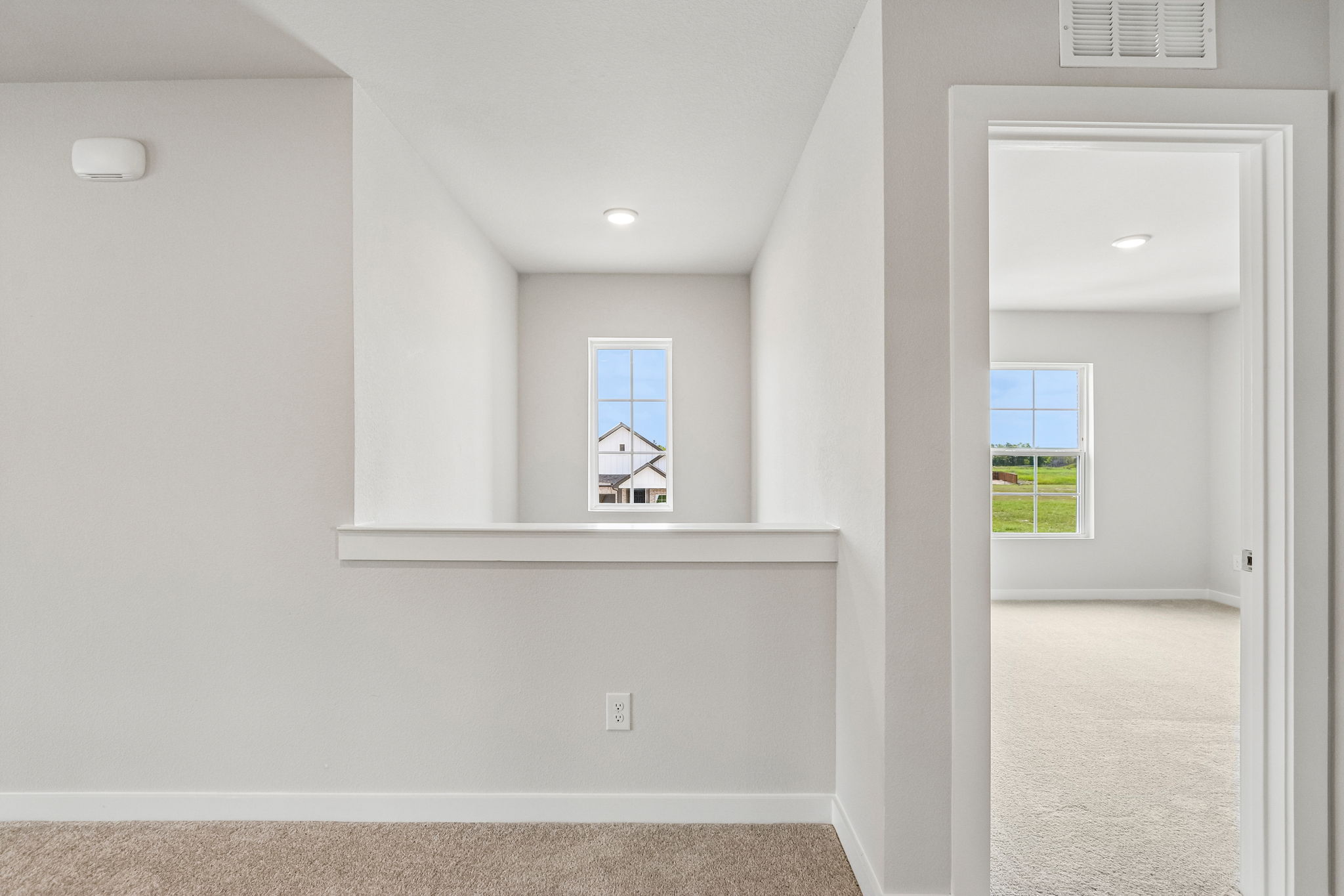 A room with a window and a shelf with a mirror.