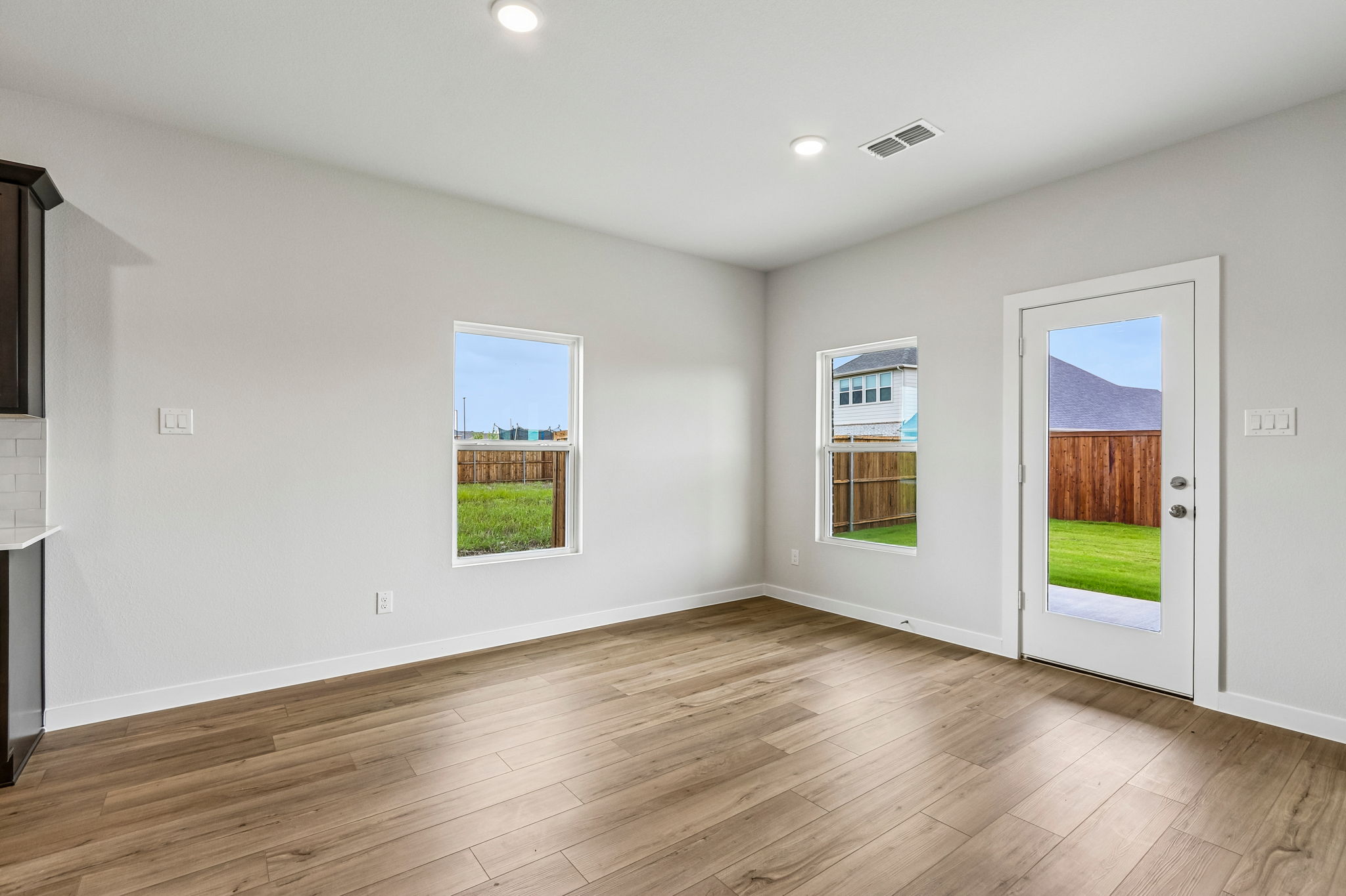 A room with a wood floor and a wood floor with a door and windows.