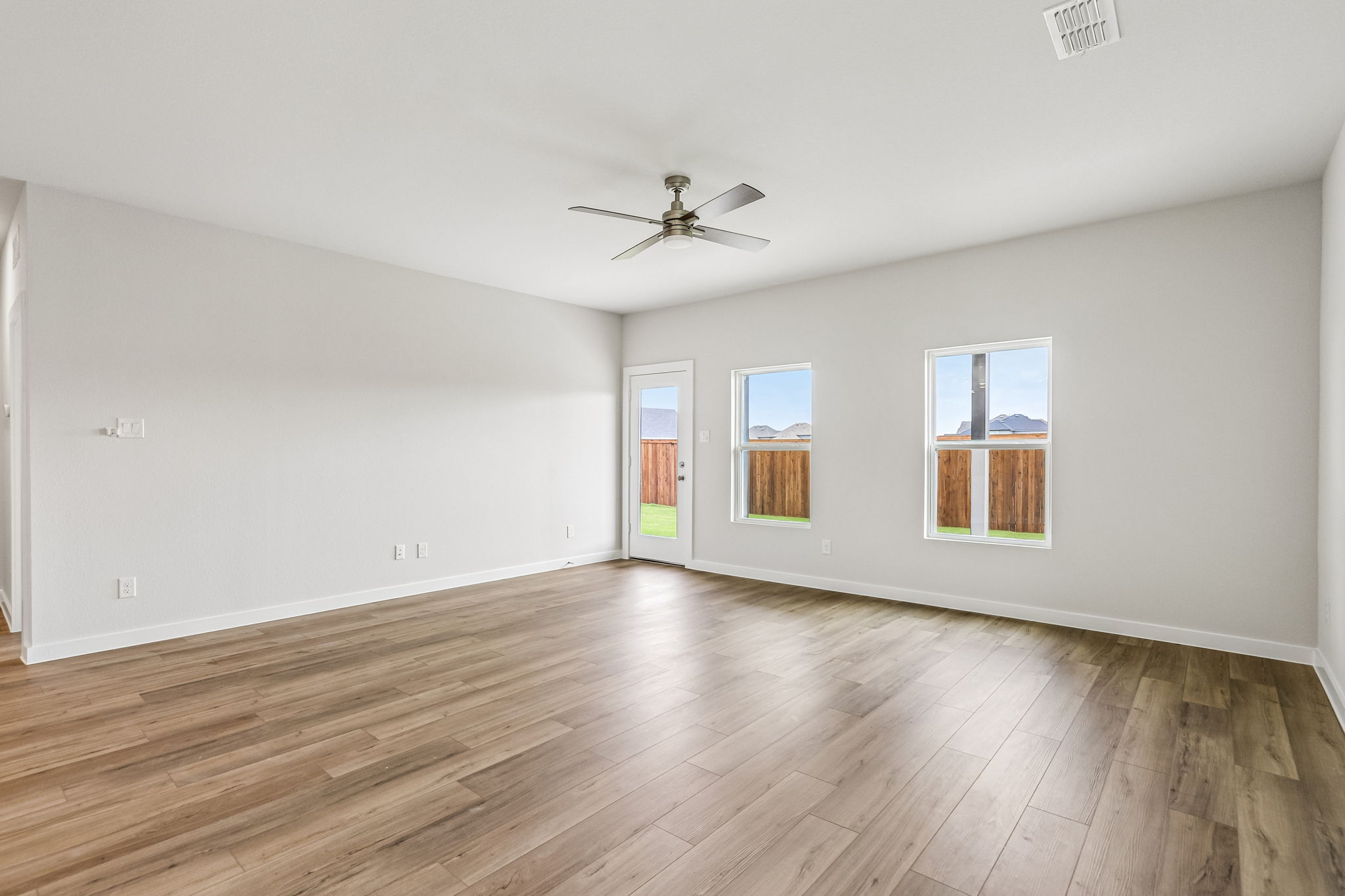 A room with a wood floor and a ceiling fan.