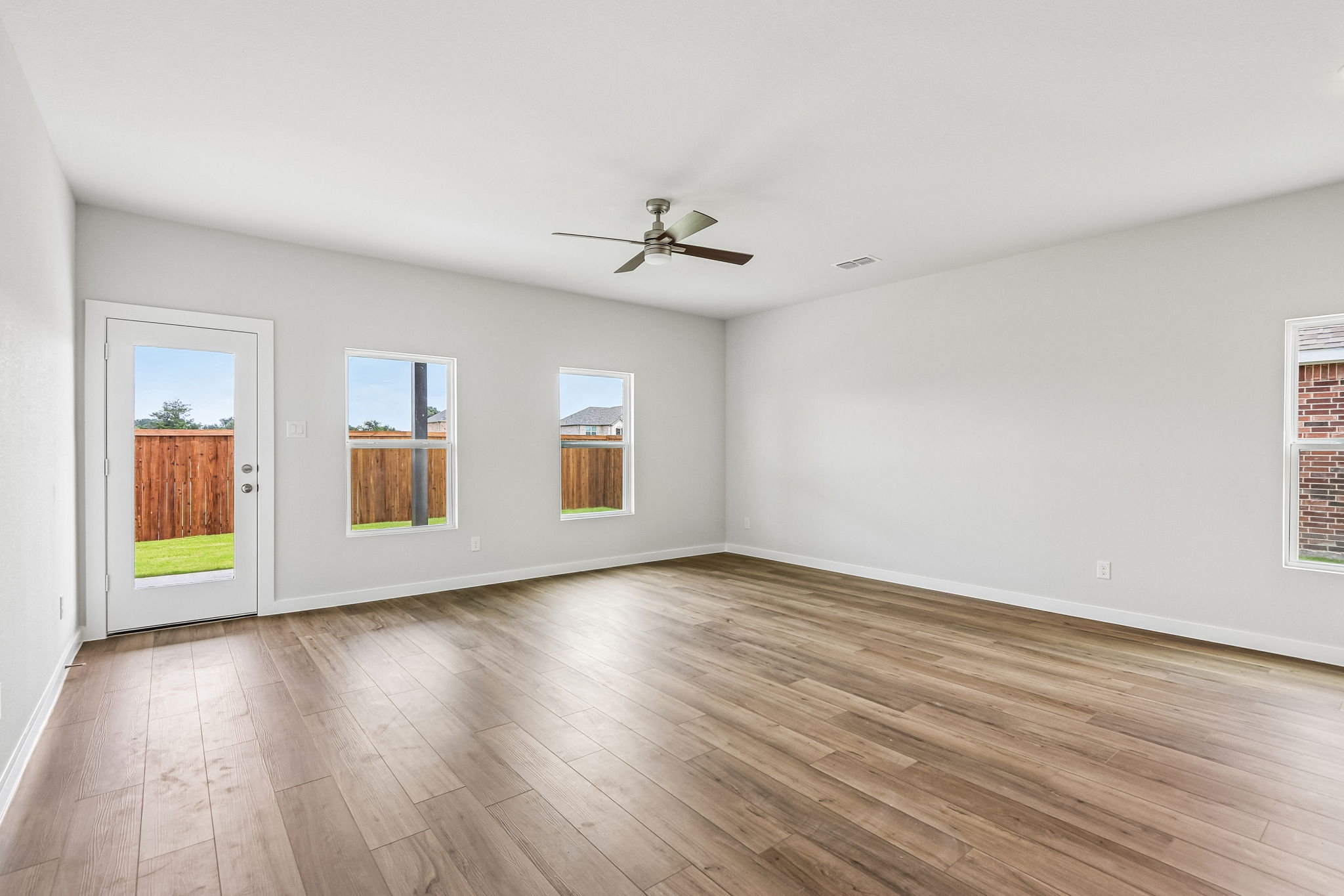 A room with a wood floor and a ceiling fan.