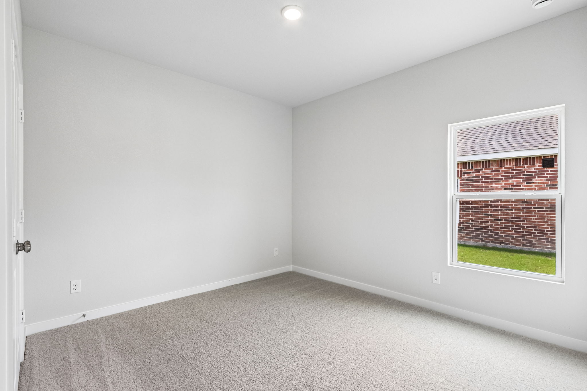 A room with a window and a carpet.
