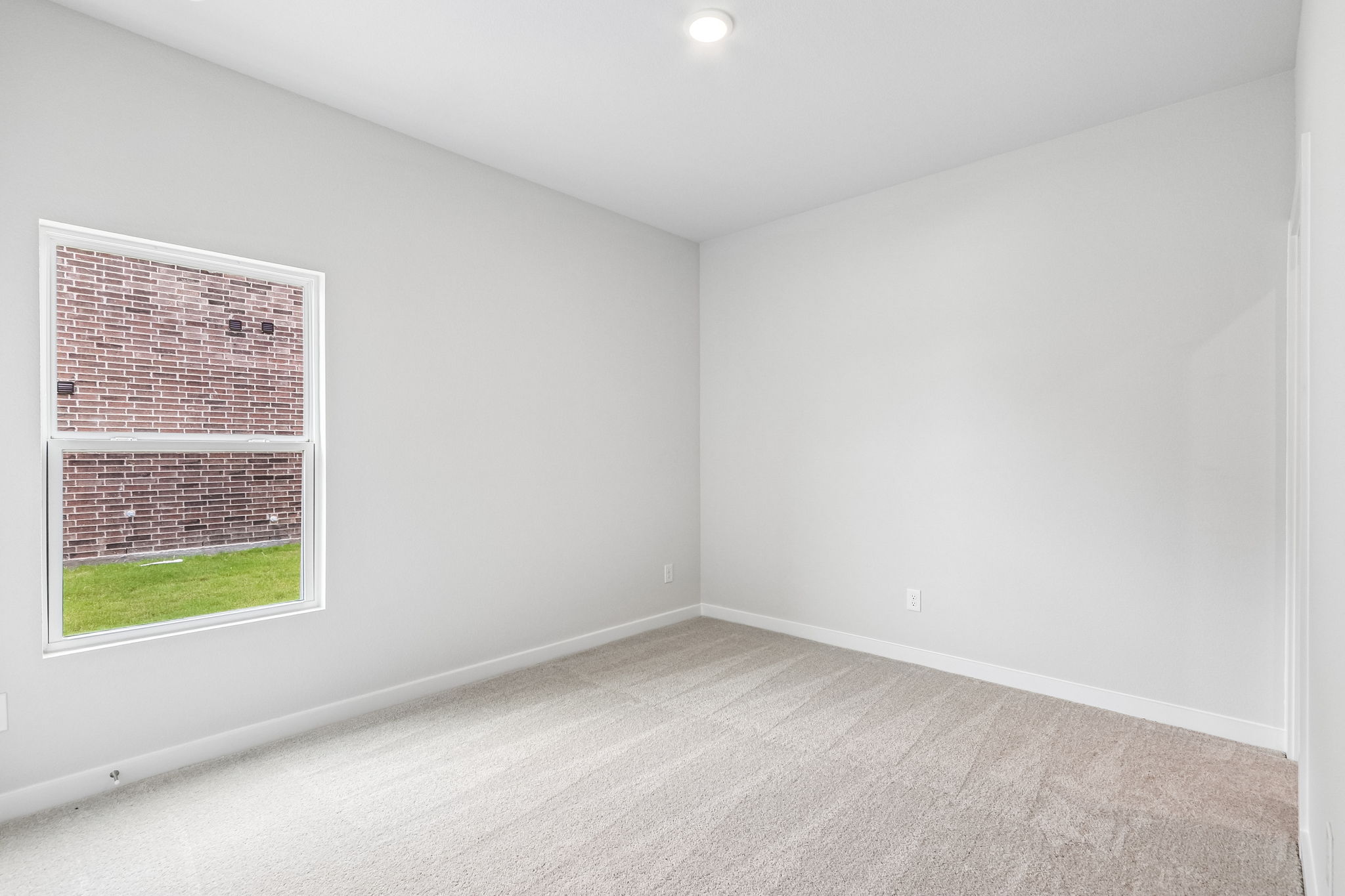 A room with a window and a carpet.