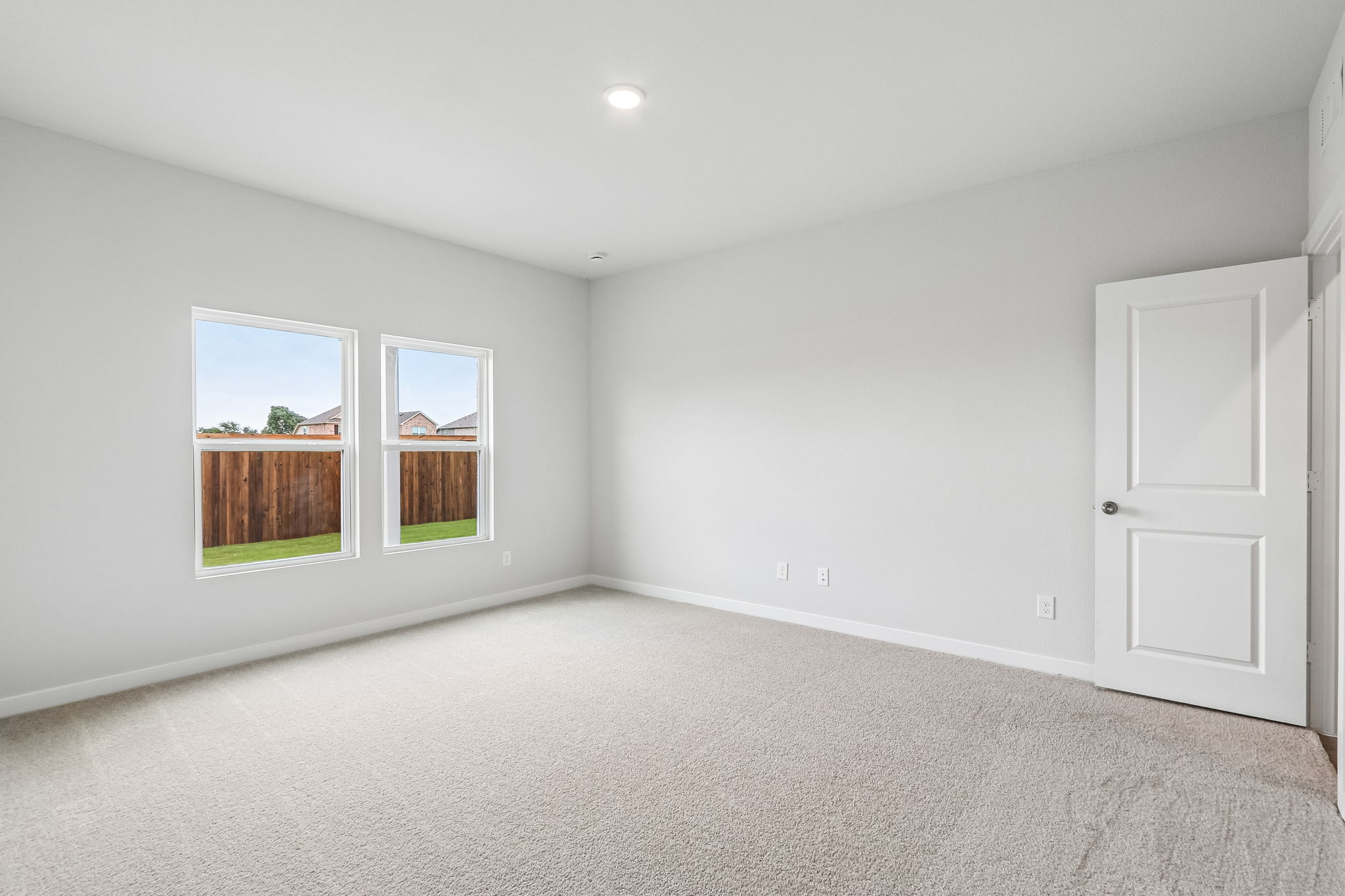 A room with a carpet and windows.