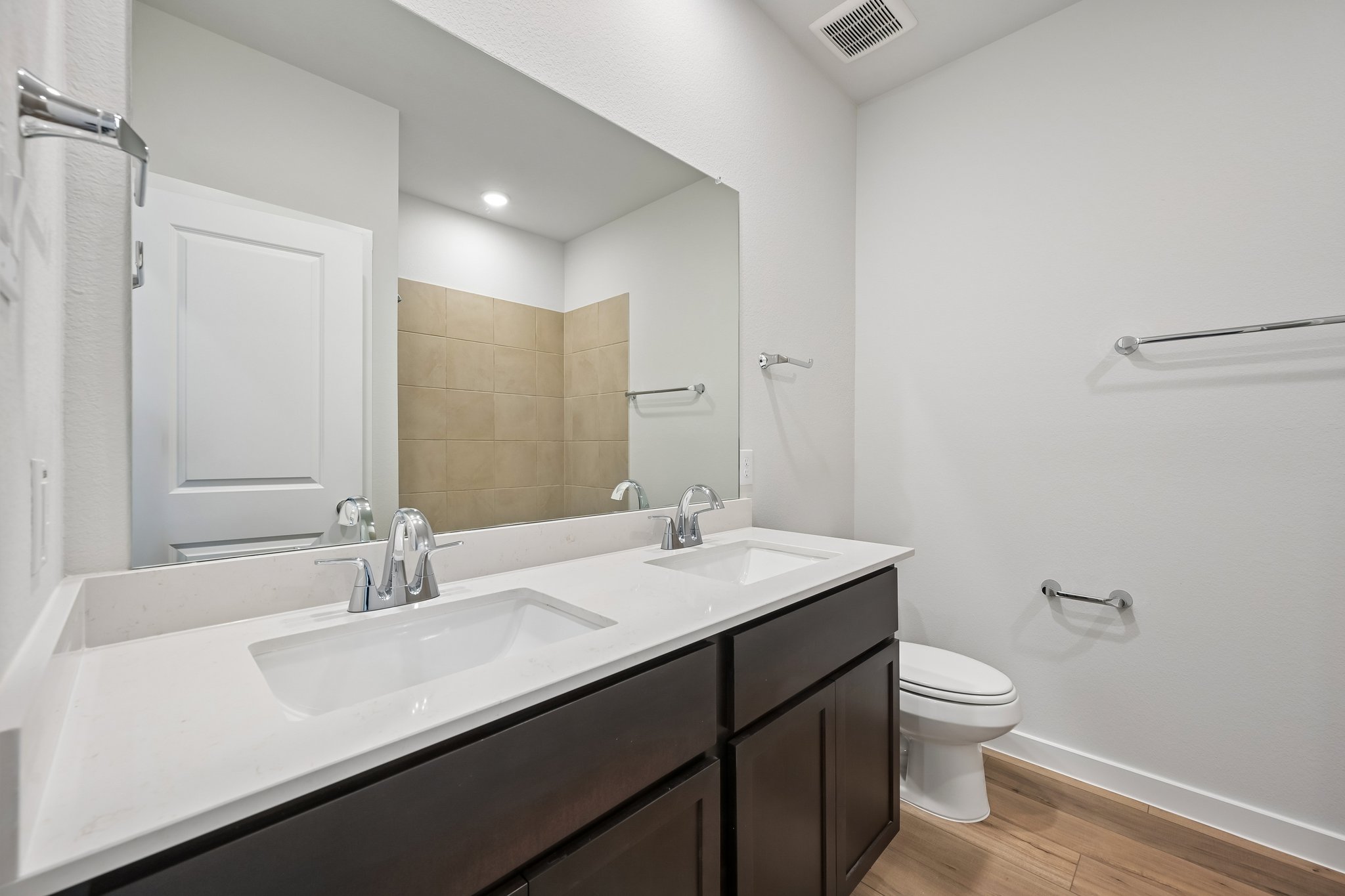 A bathroom with a sink toilet and mirror.
