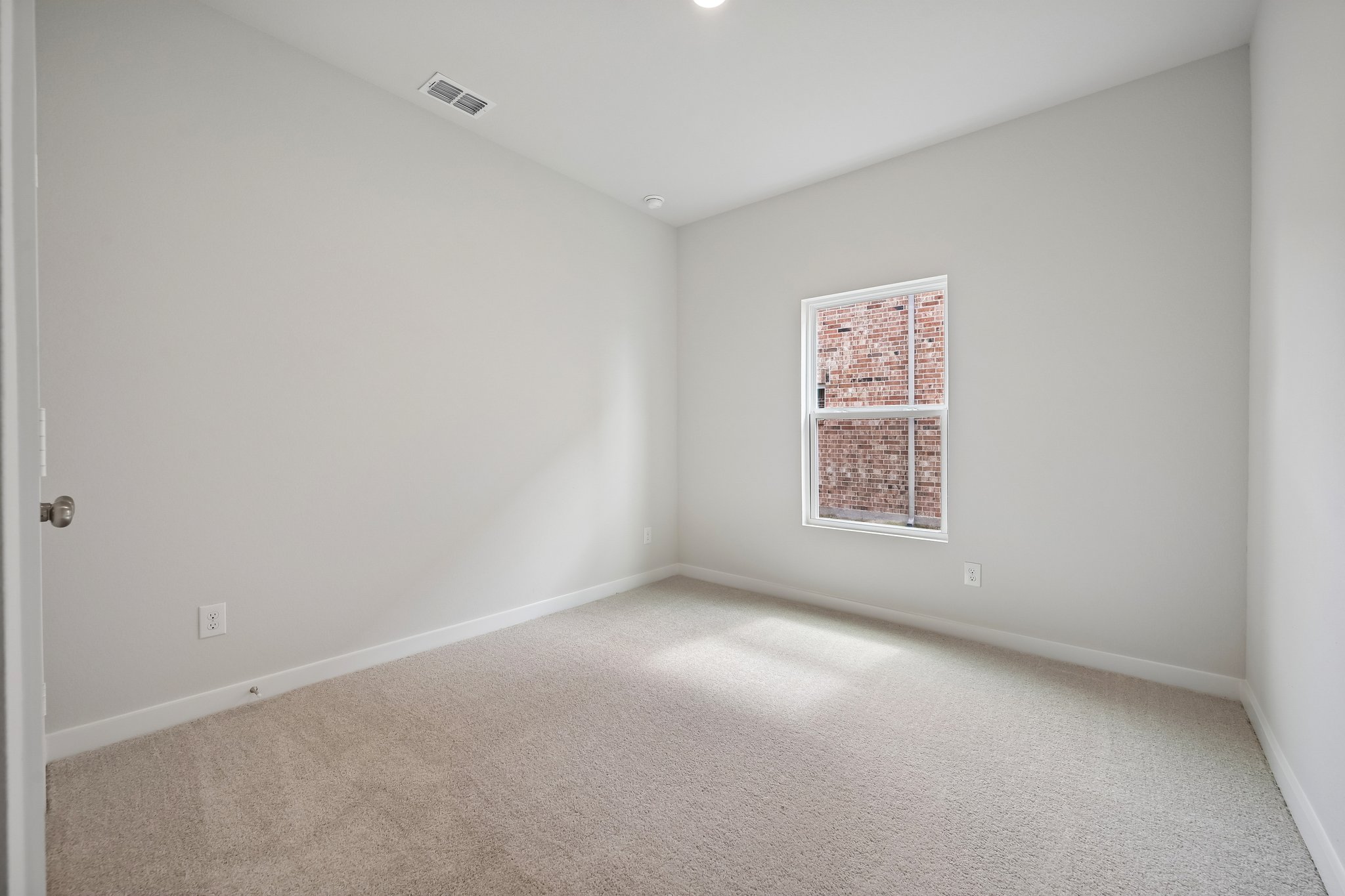 A room with a window and carpet.