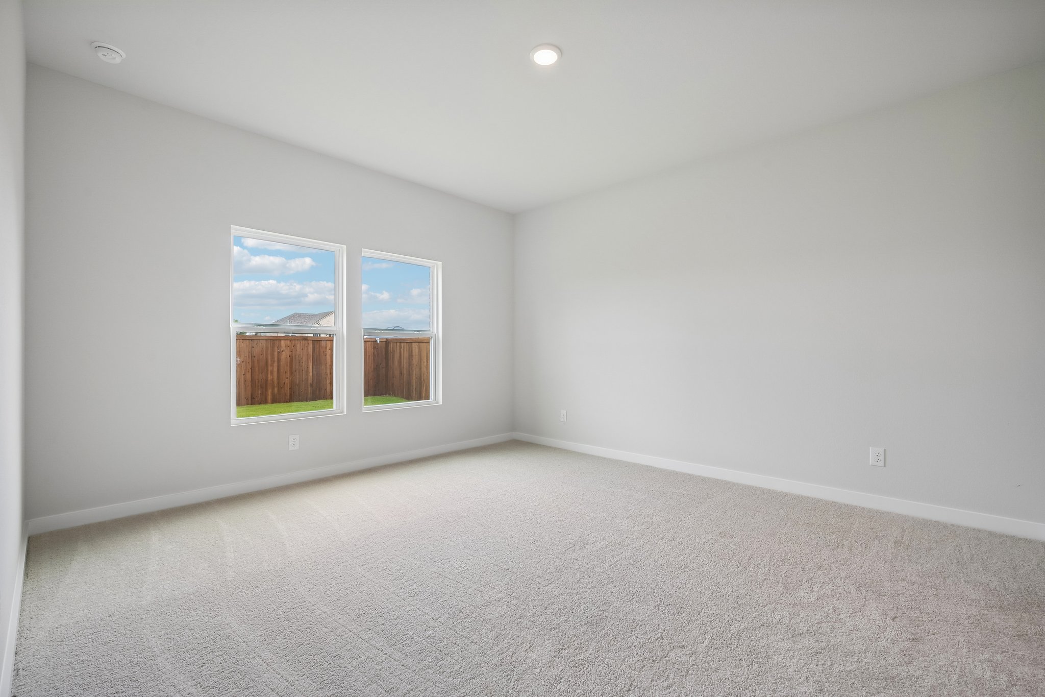 A room with a window and a carpet.