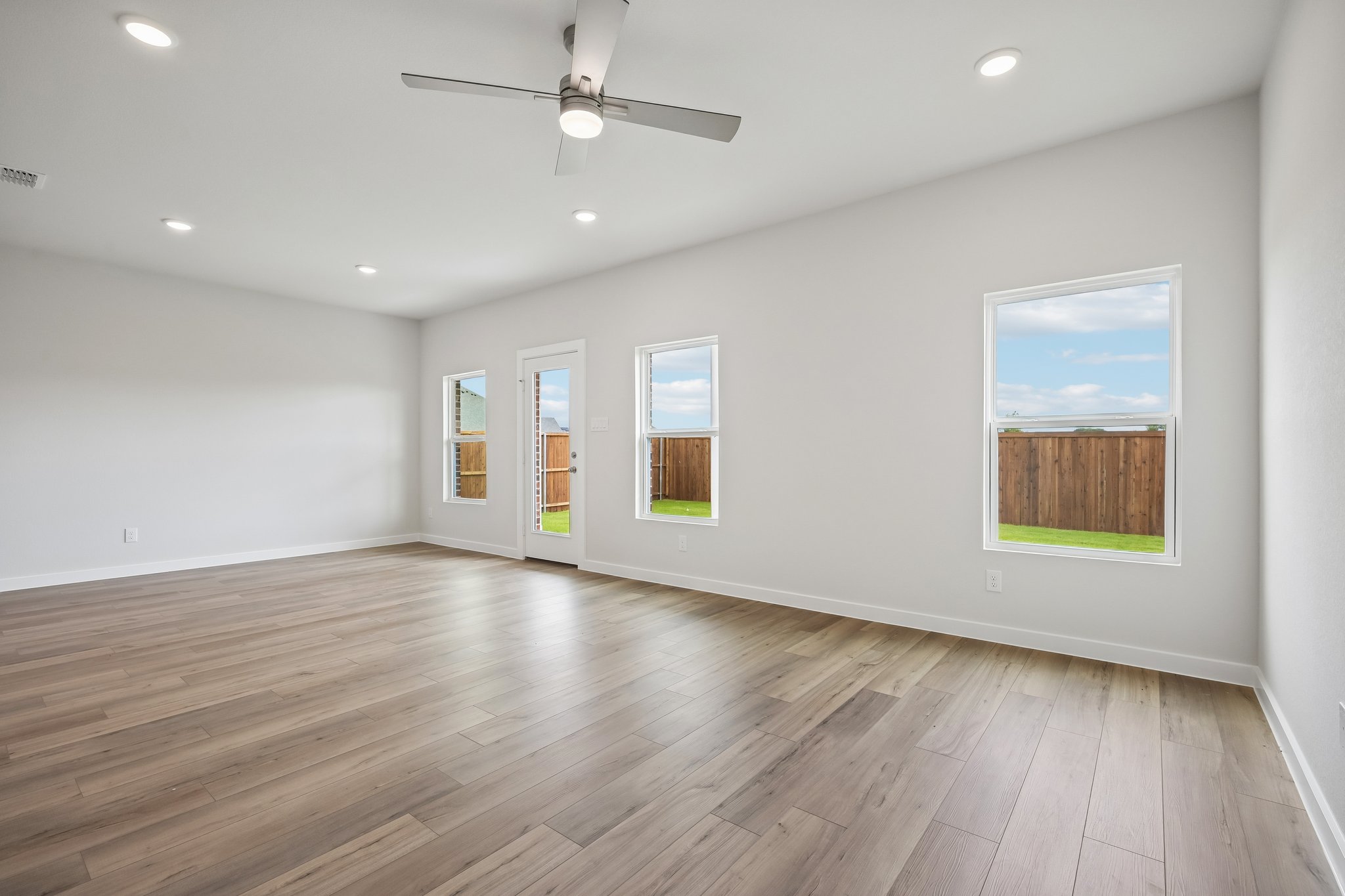 A room with a wood floor and a ceiling fan.