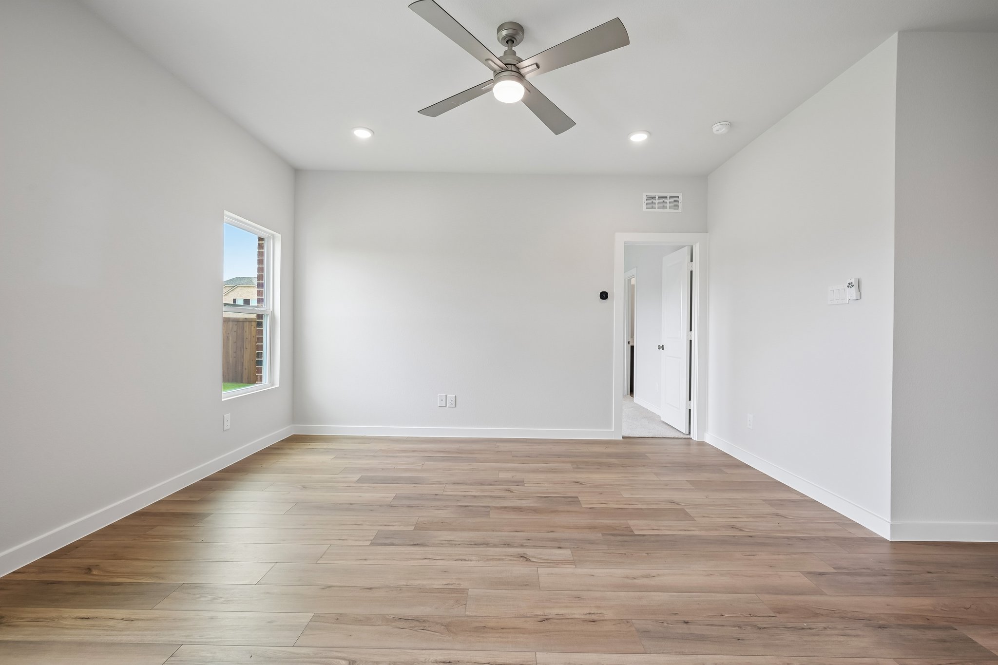 A room with a wood floor and a ceiling fan.