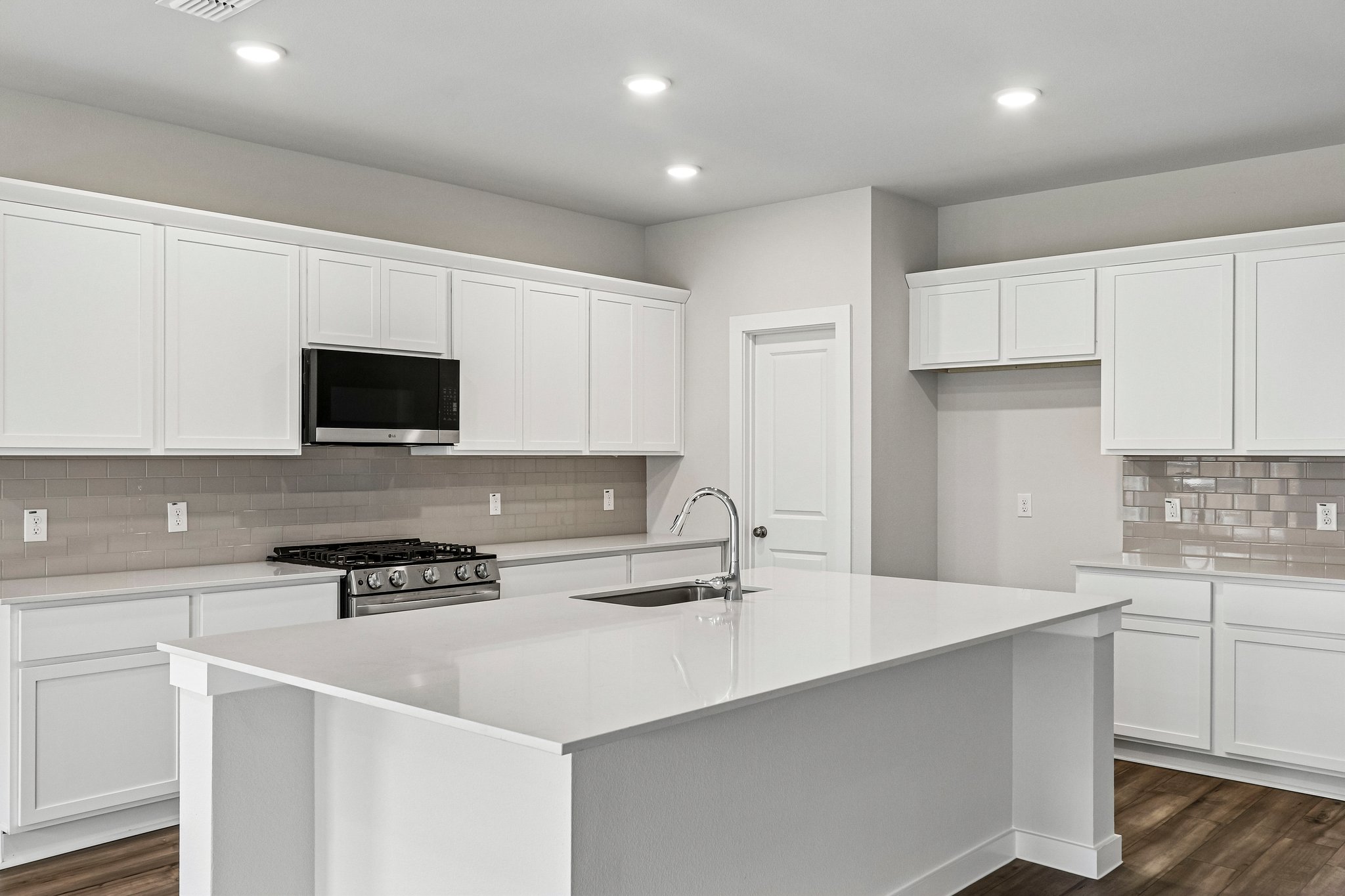 A kitchen with white cabinets.