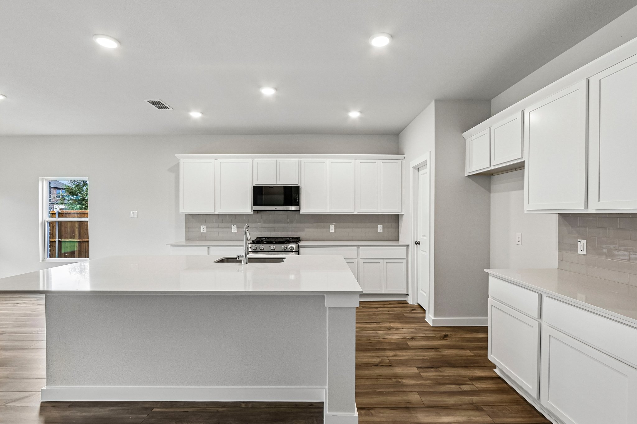 A kitchen with white cabinets.