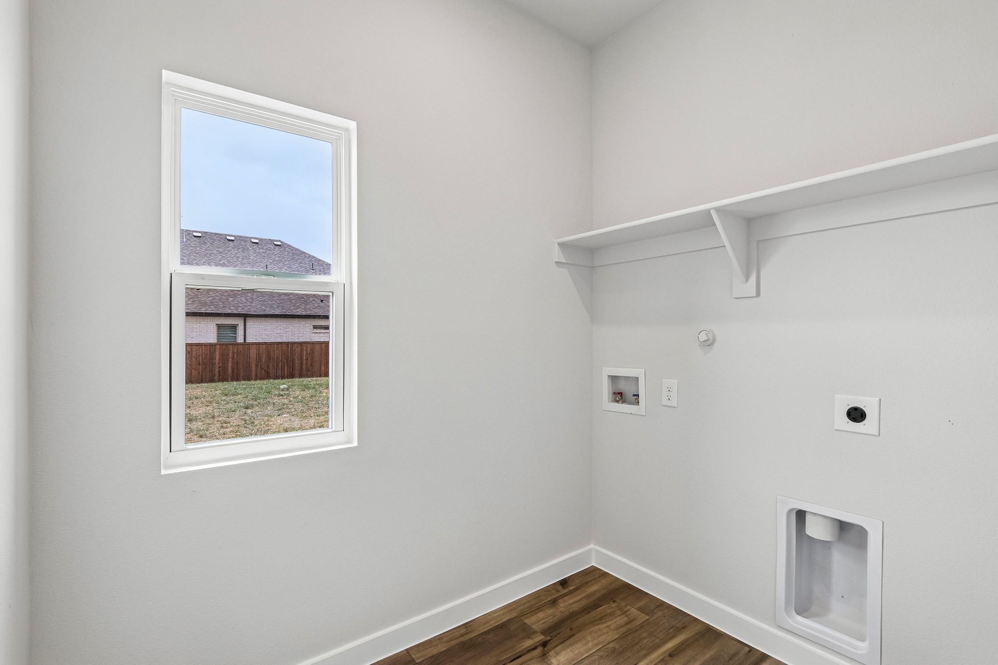 A room with a window and a wood floor.