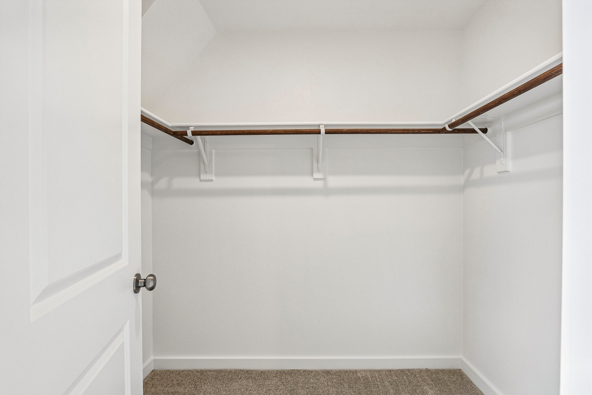A white door with a metal bar.