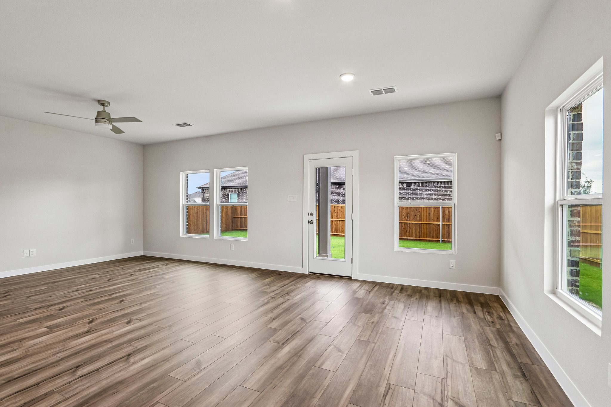 A room with a wood floor and windows.