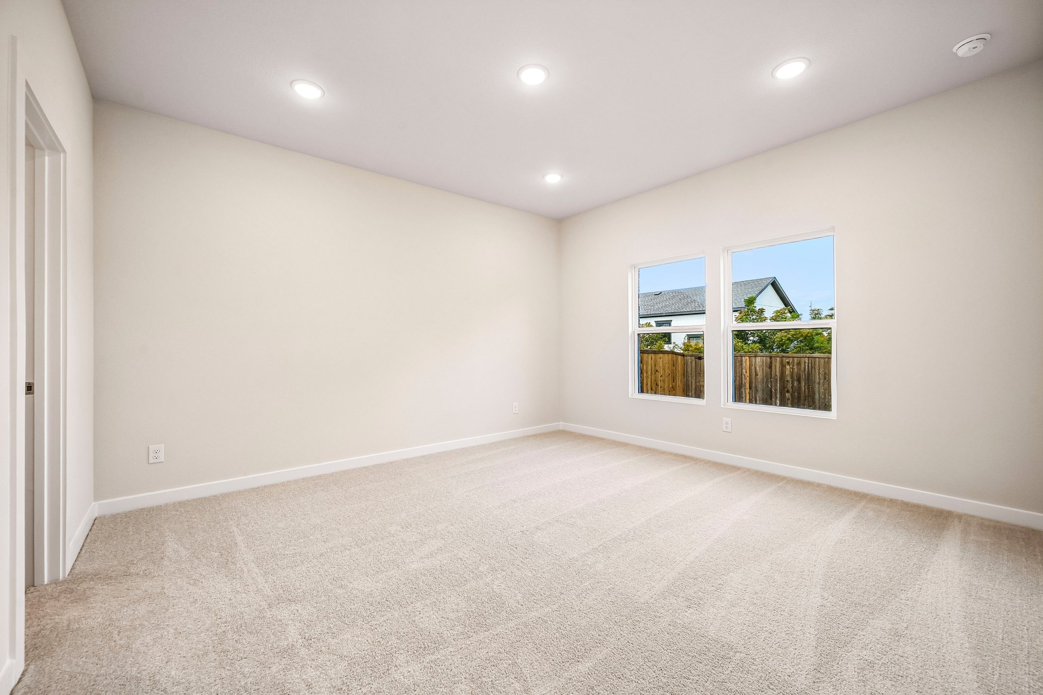 A room with a window and a rug.