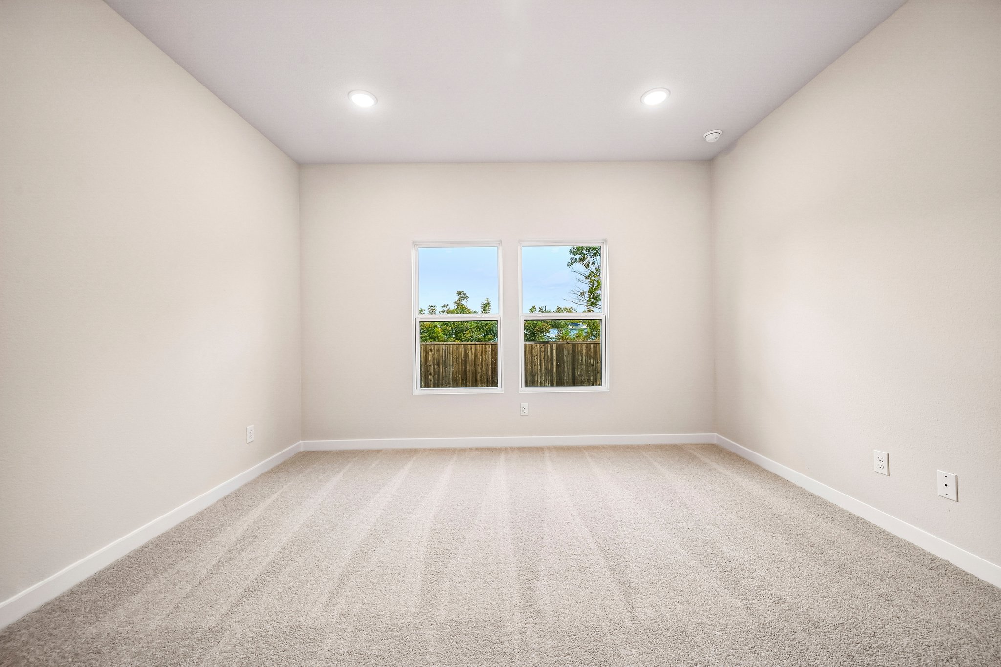 A room with a window and a white carpet.