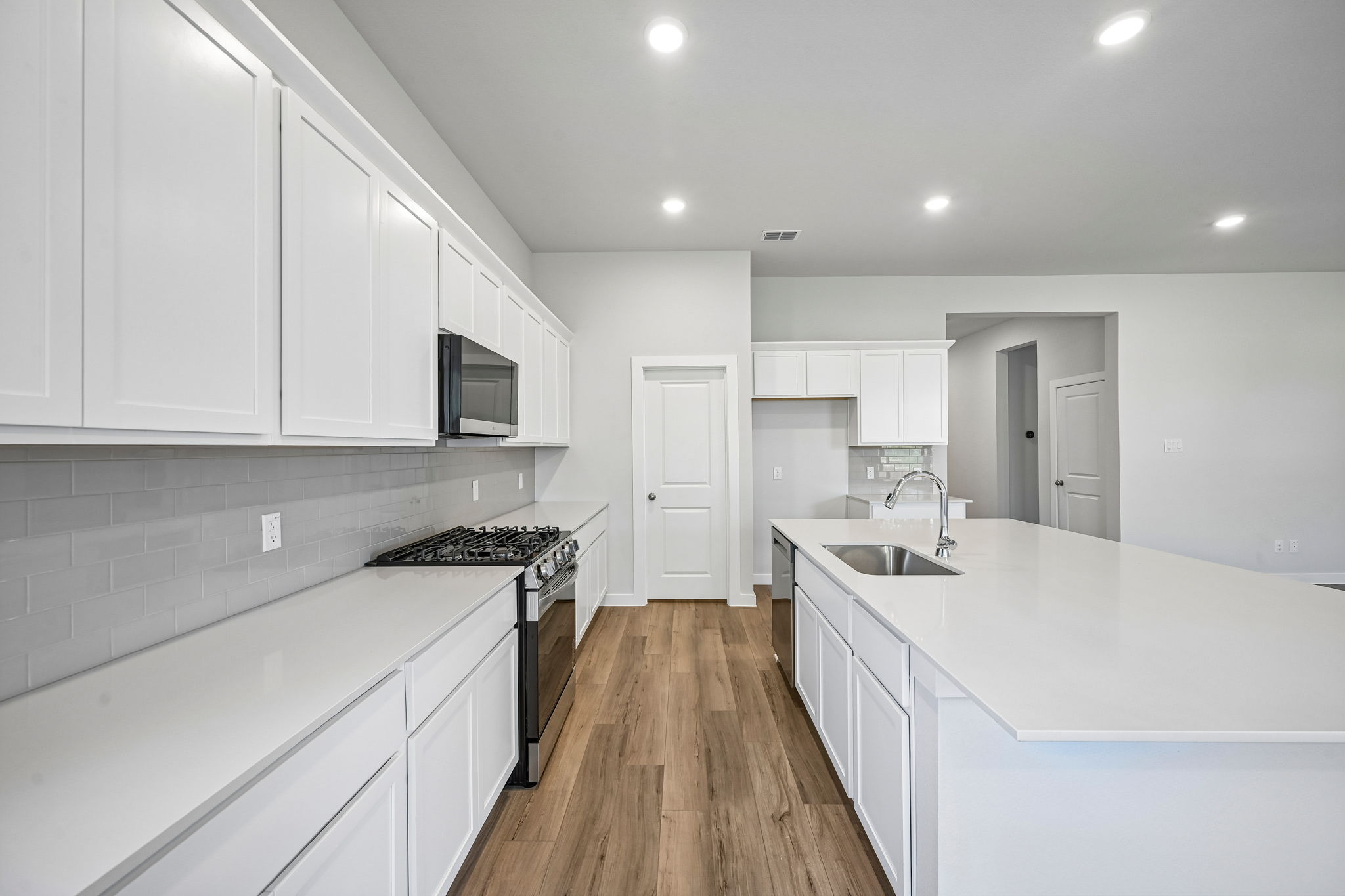 A kitchen with white cabinets.