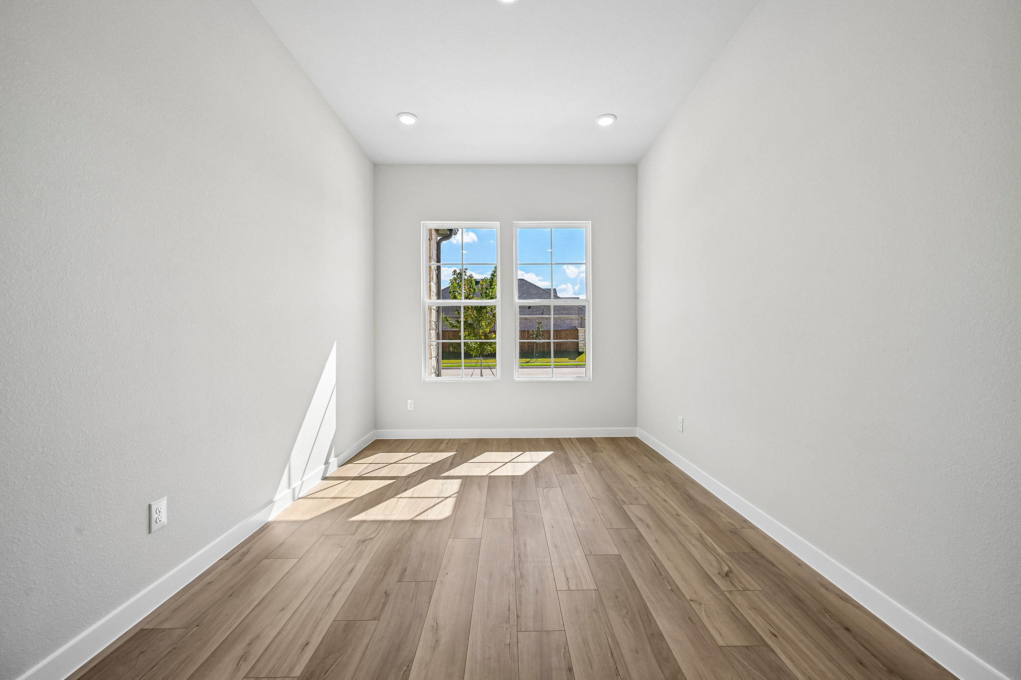 A room with a wood floor and a window with a wood floor.