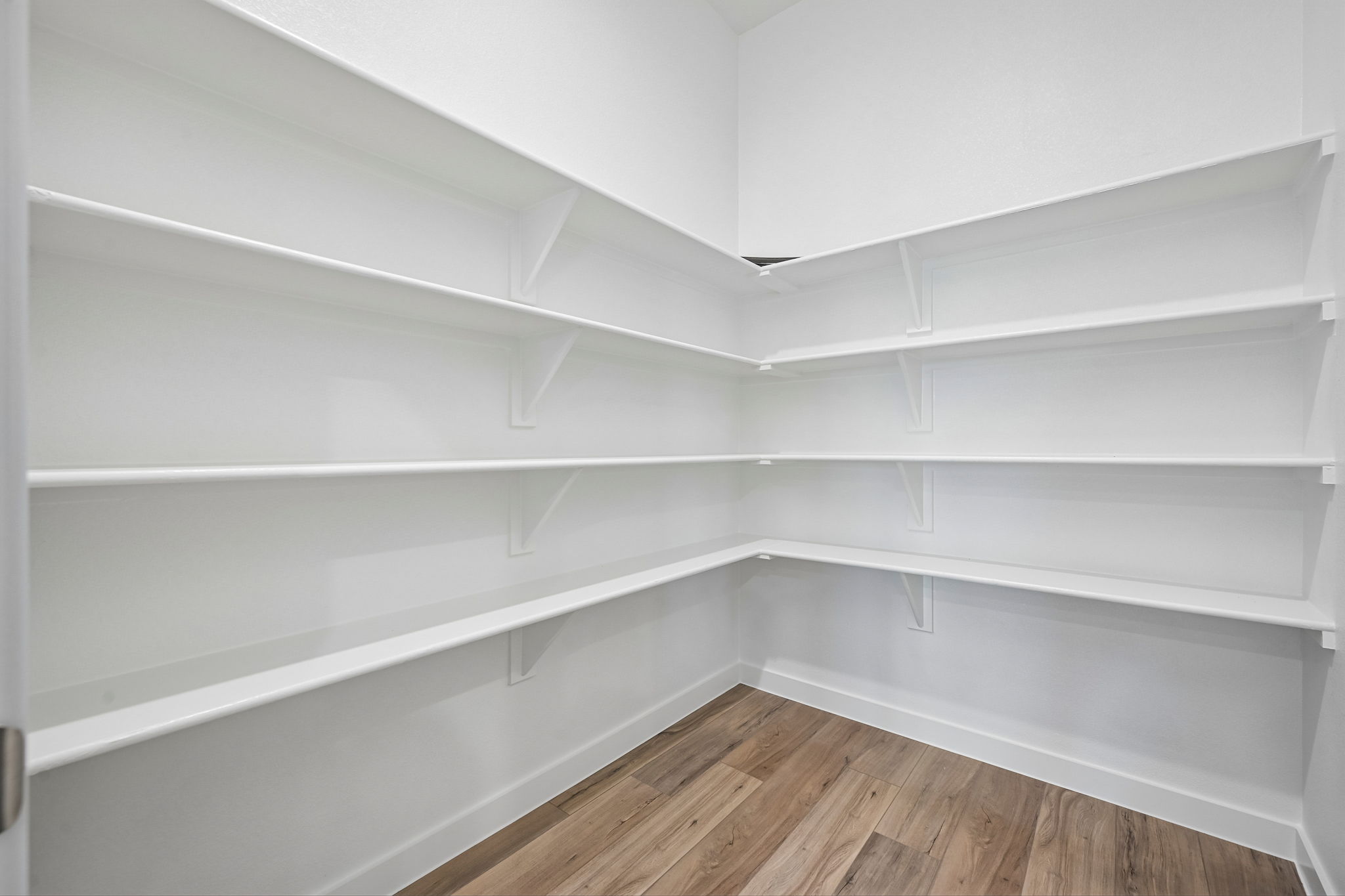 A white shelf with a wooden floor.