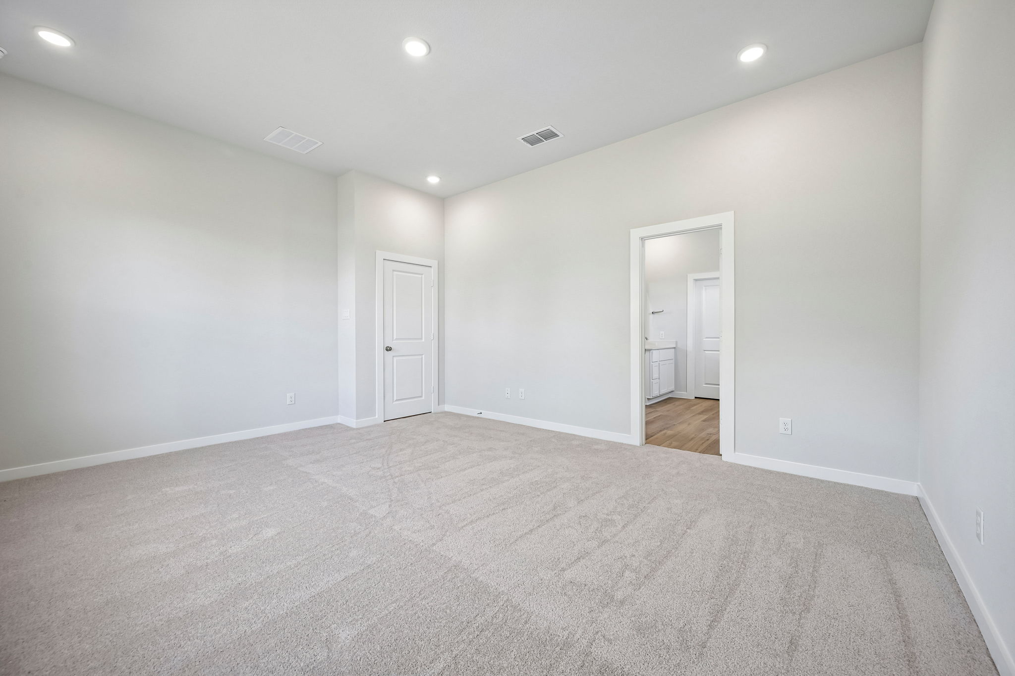 A long hallway with white doors.