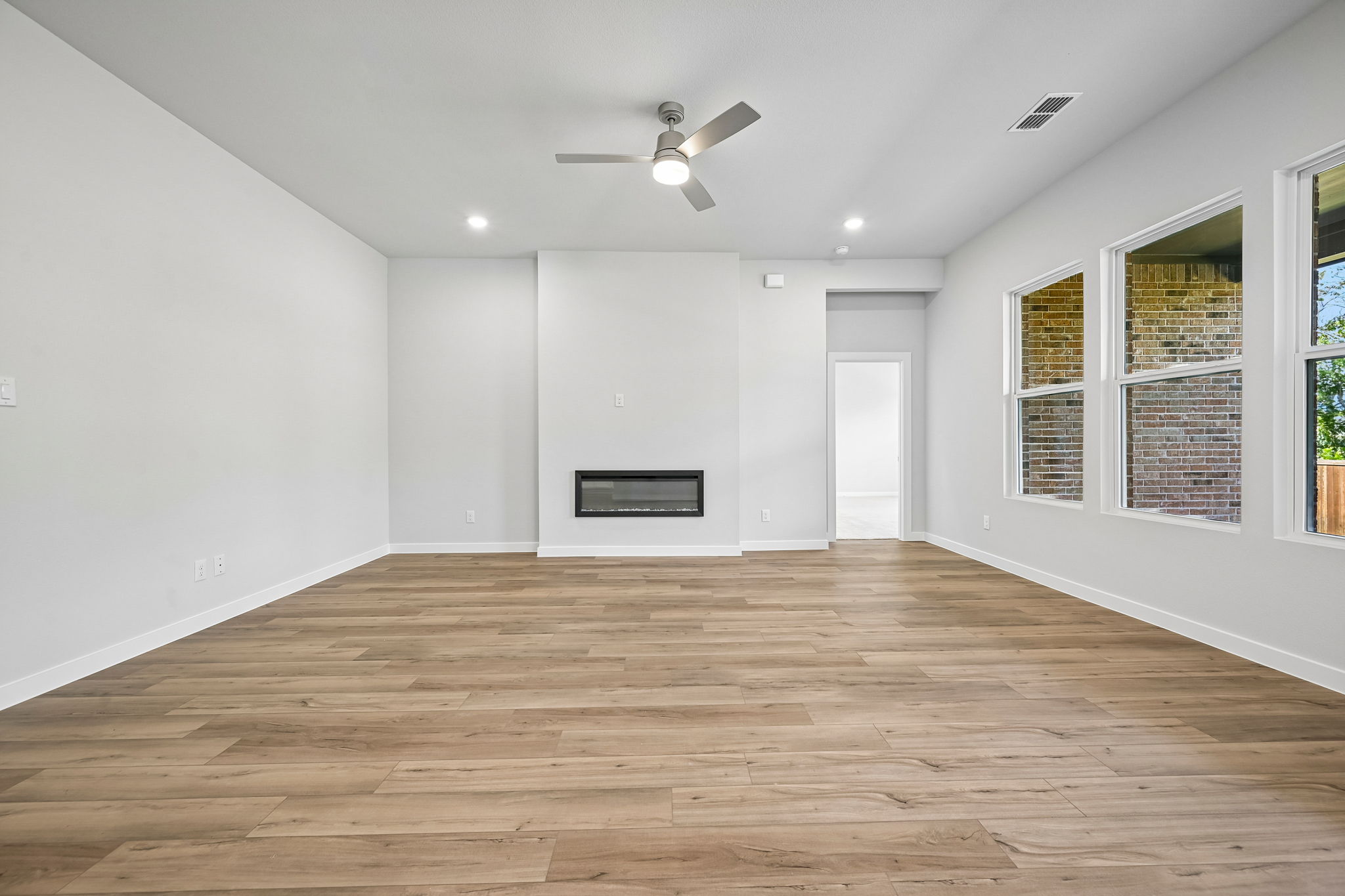 A room with a wood floor and a ceiling fan.