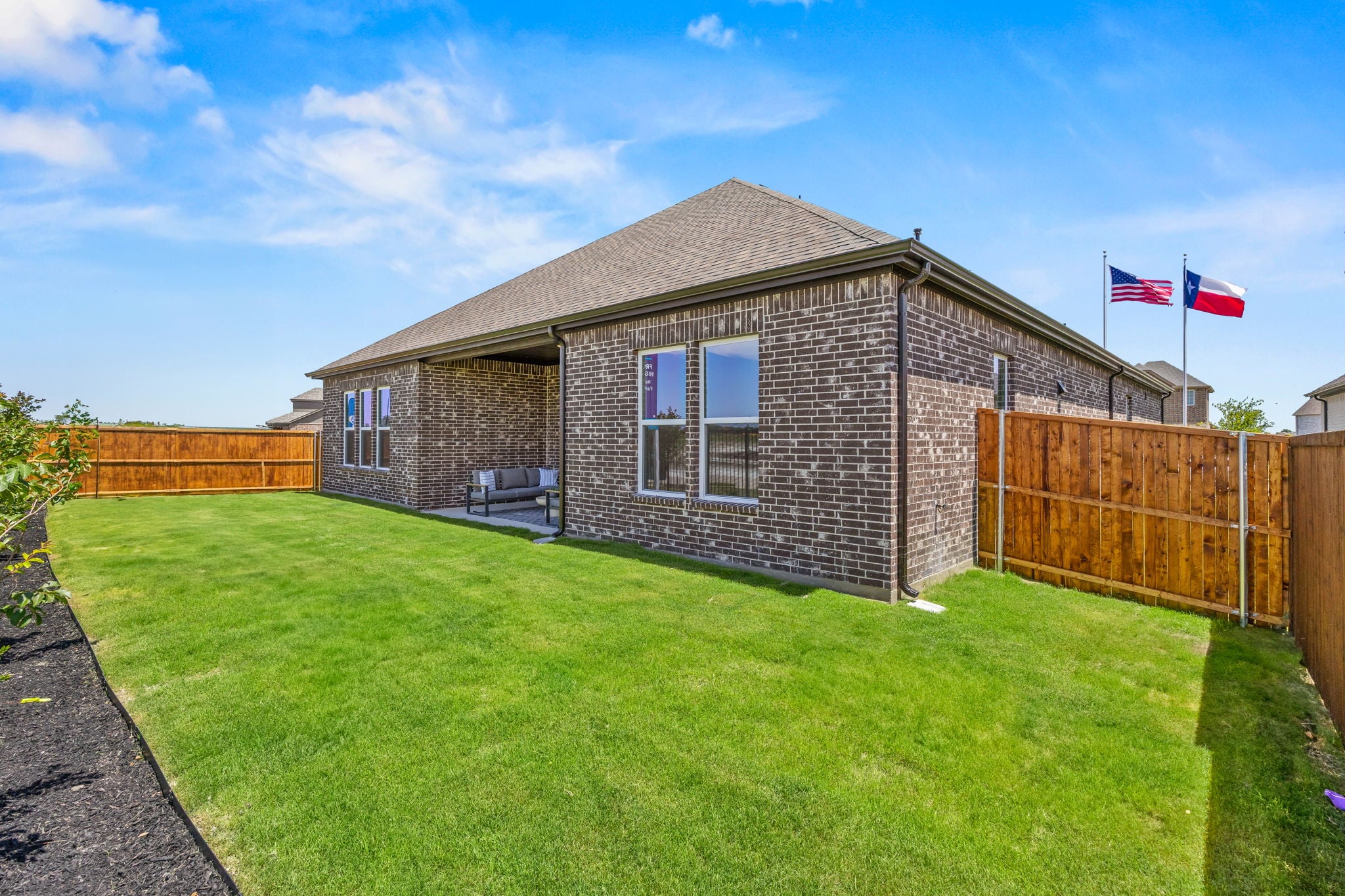 A brick house with flags on the side.