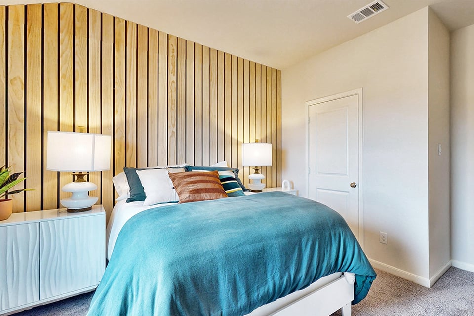 A bed with a blue comforter.