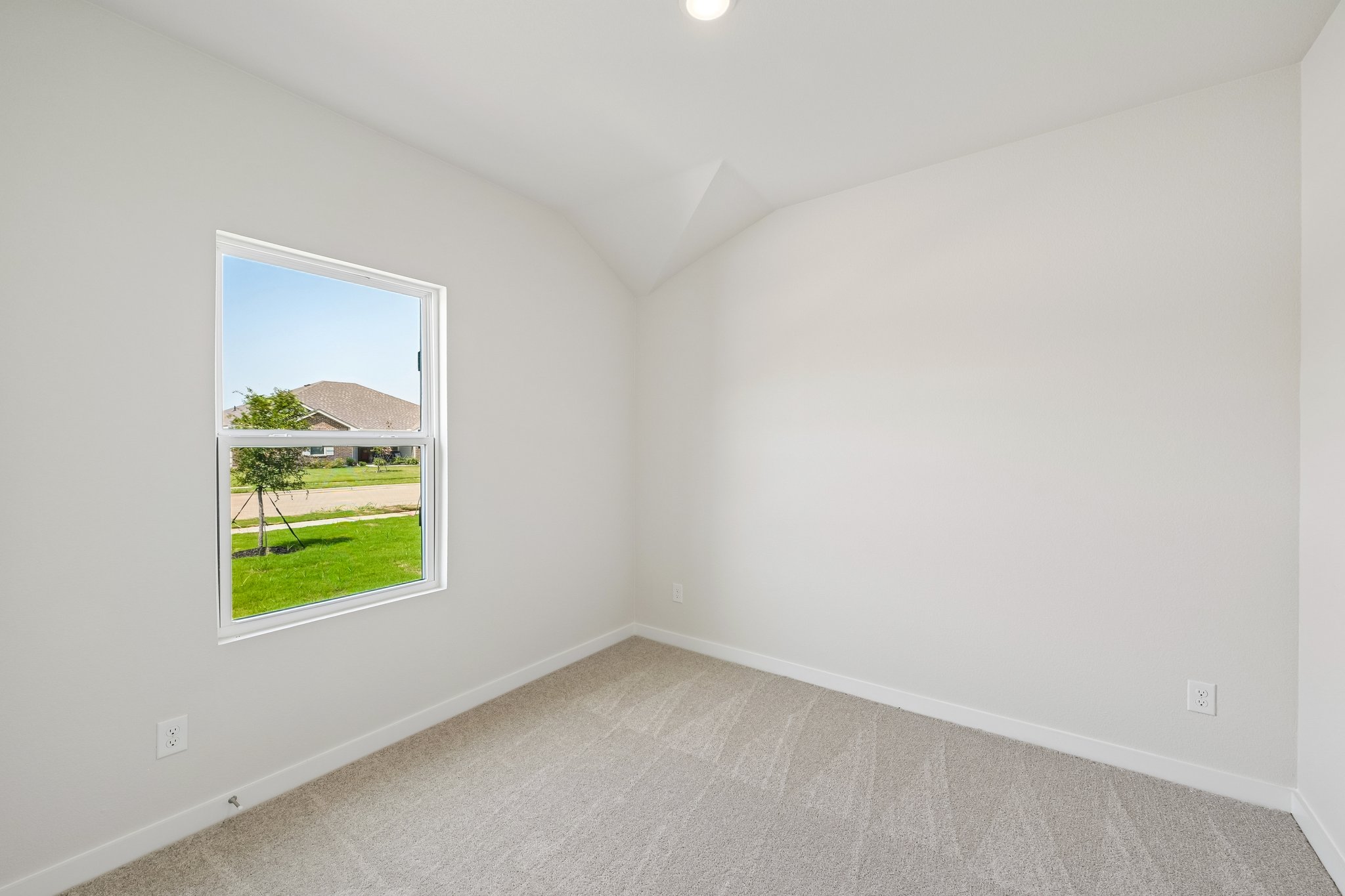 A room with a window and a green field.