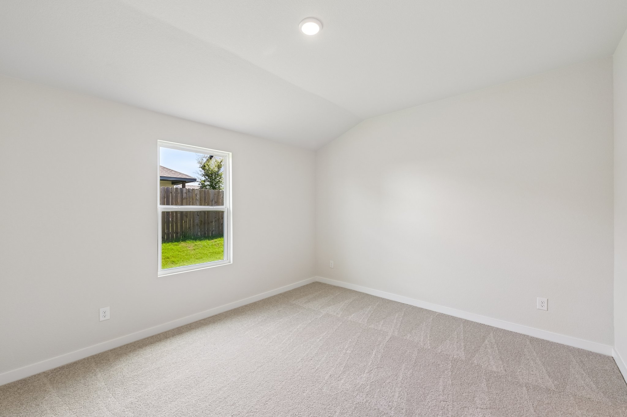 A room with a window and a carpet.