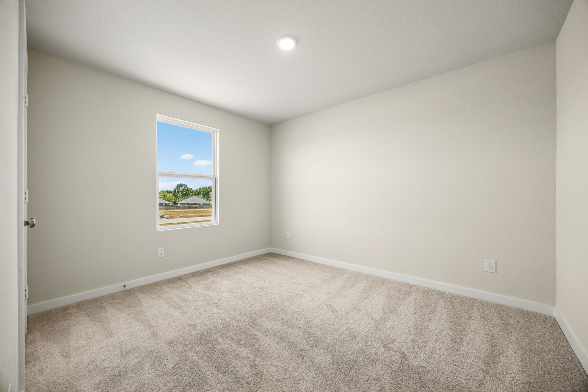 A room with a carpet and a window.
