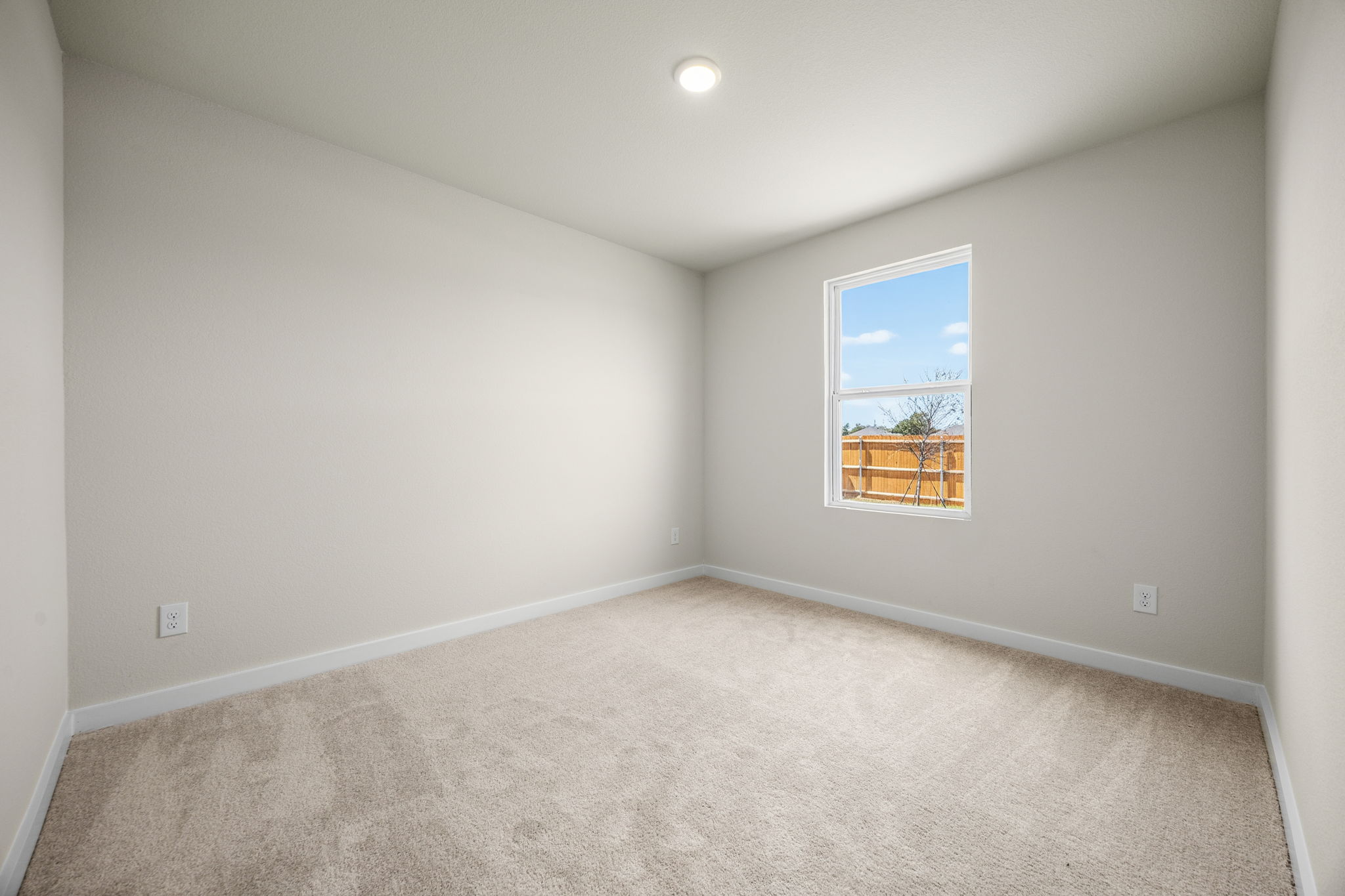 A room with a window and a carpet.