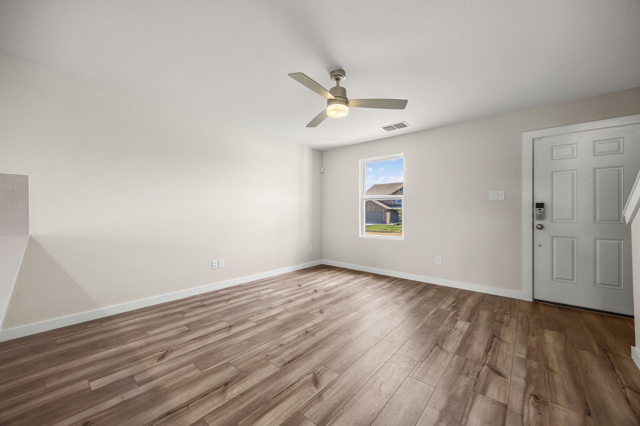A room with a wood floor and a ceiling fan.