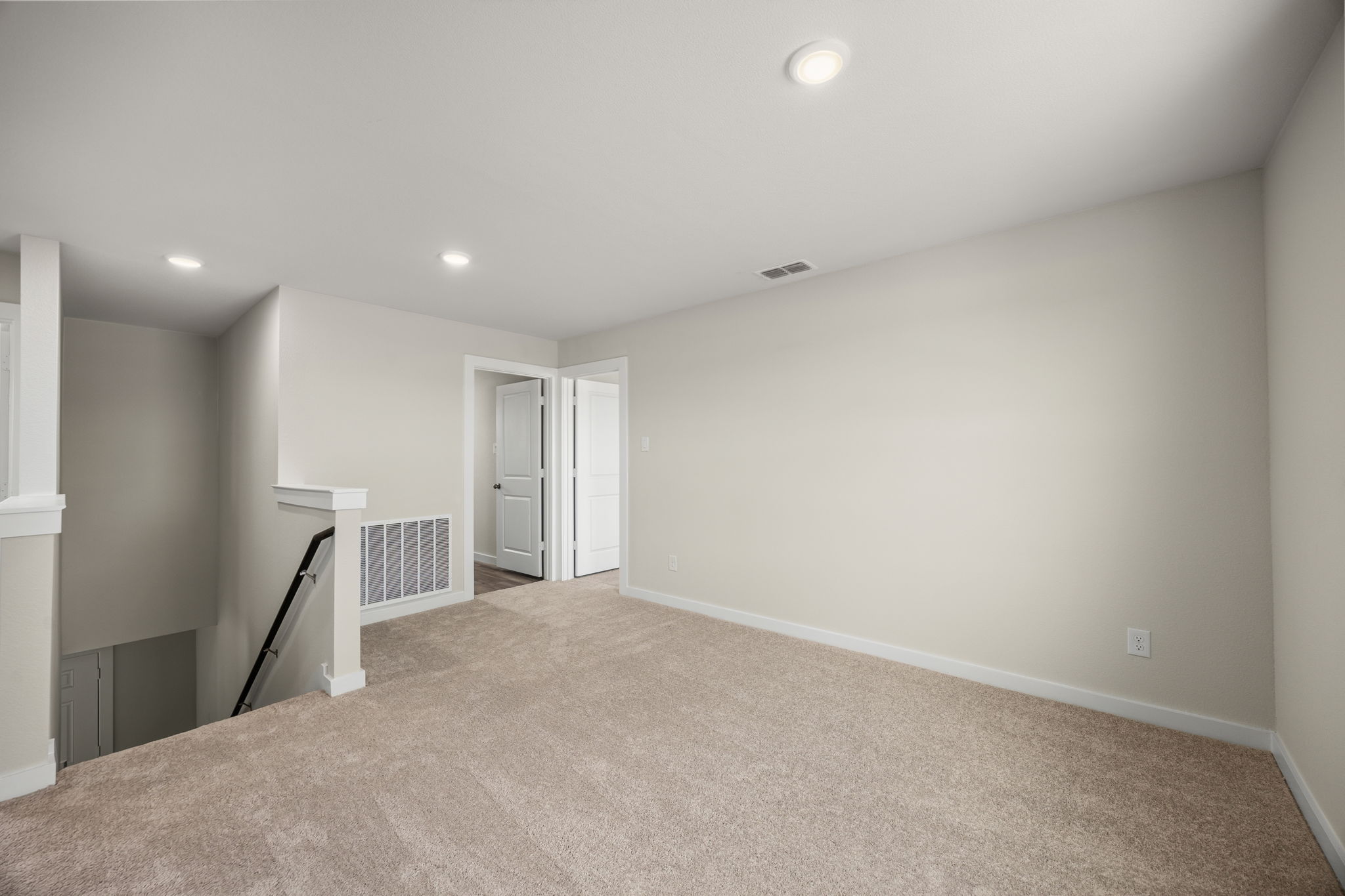 A room with a carpet and a vacuum.