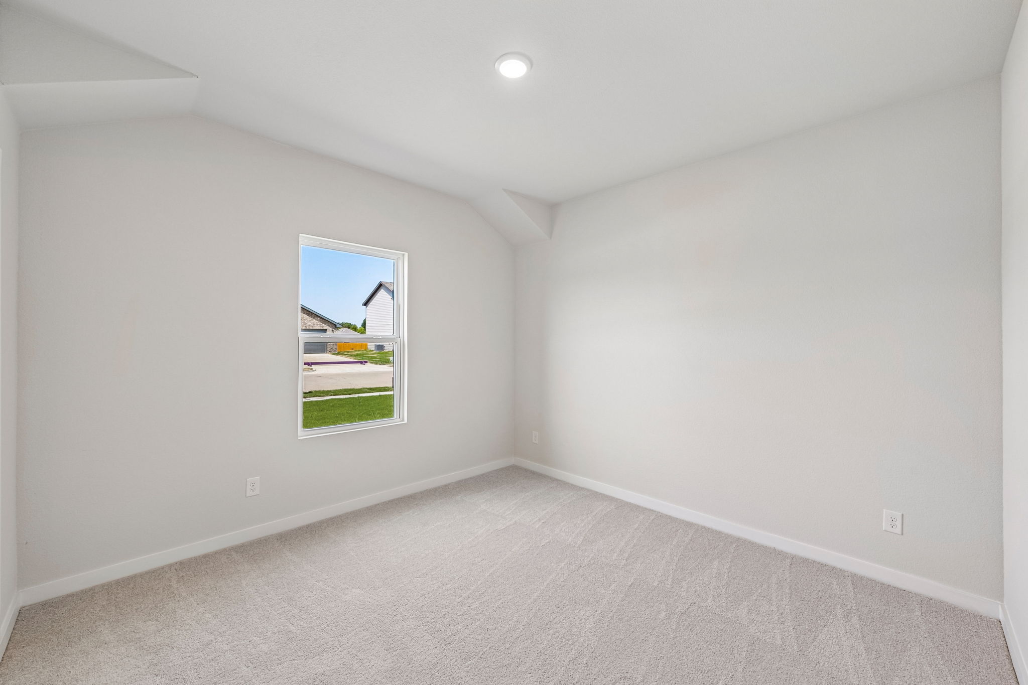 A room with a window and a white wall.