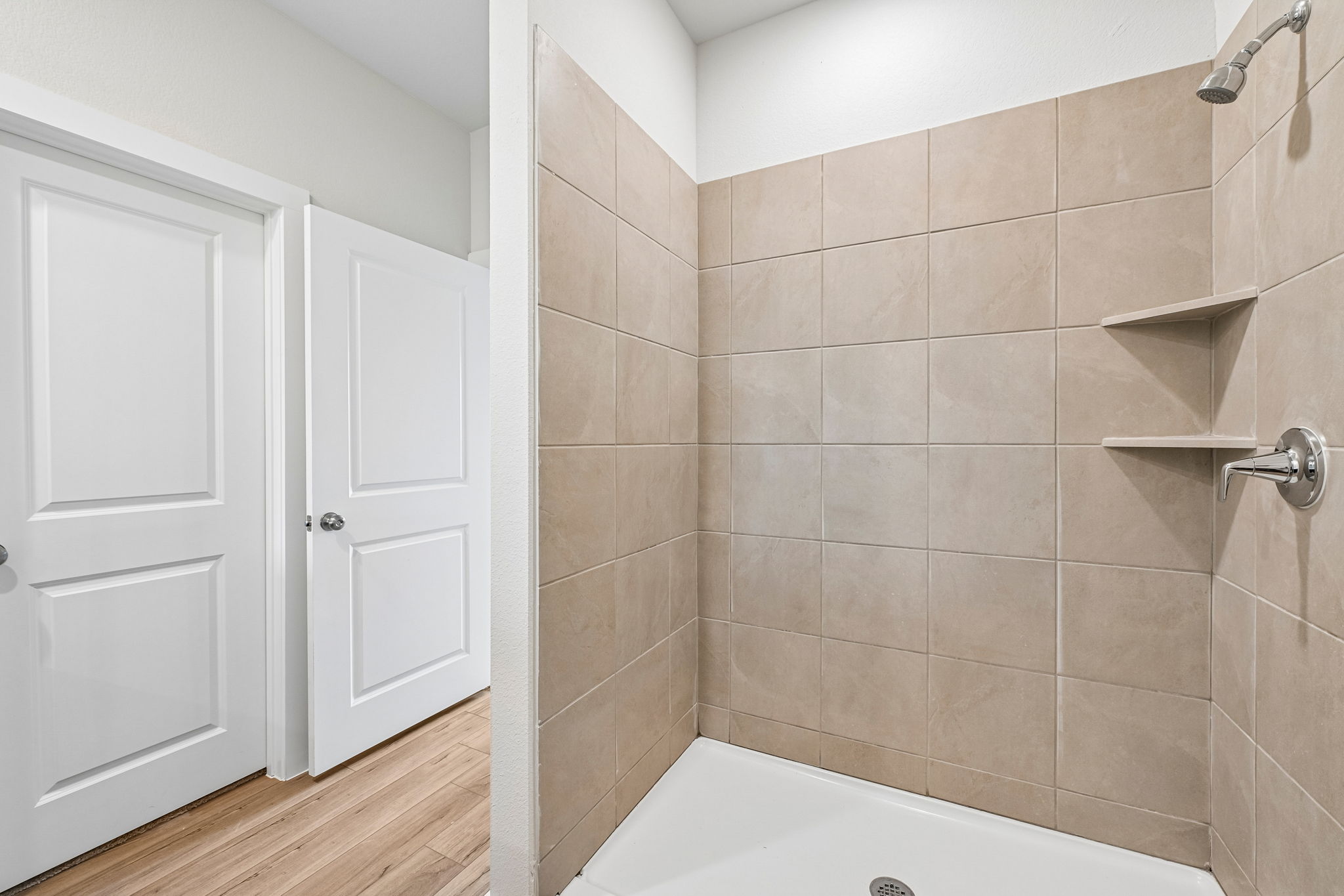 A bathroom with a bathtub and a shower unit.