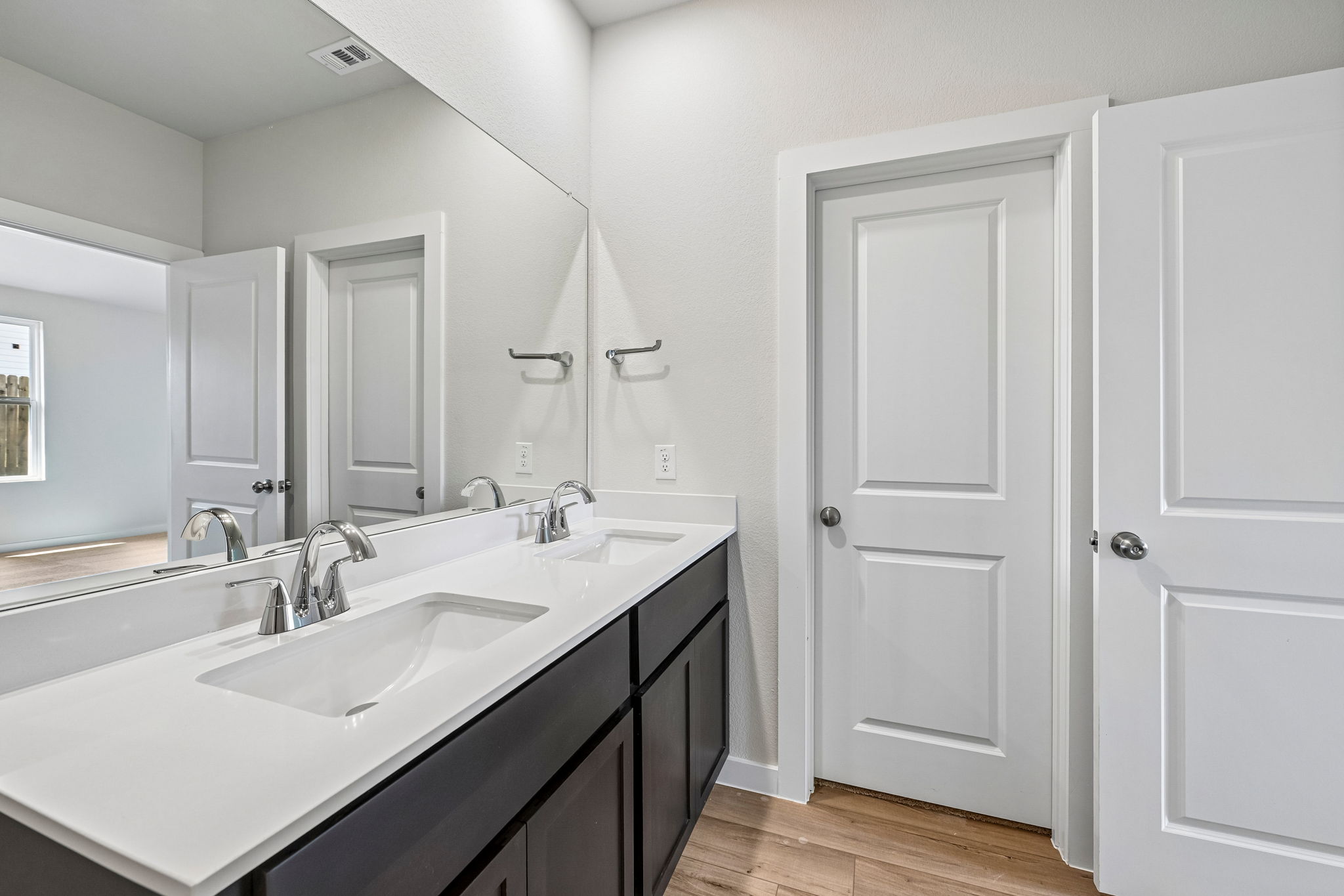 A bathroom with white cabinets.