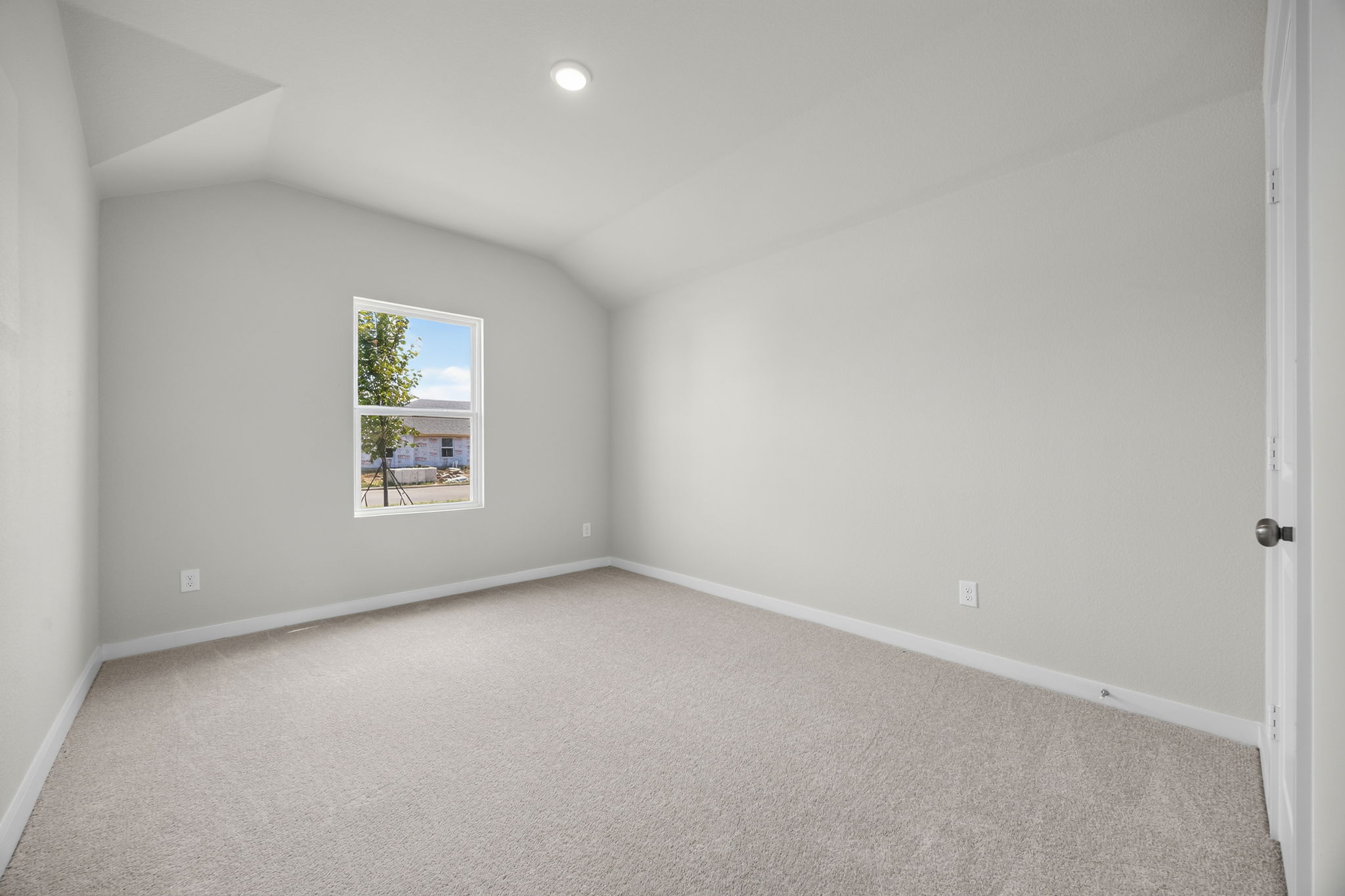 A room with a window and carpet.