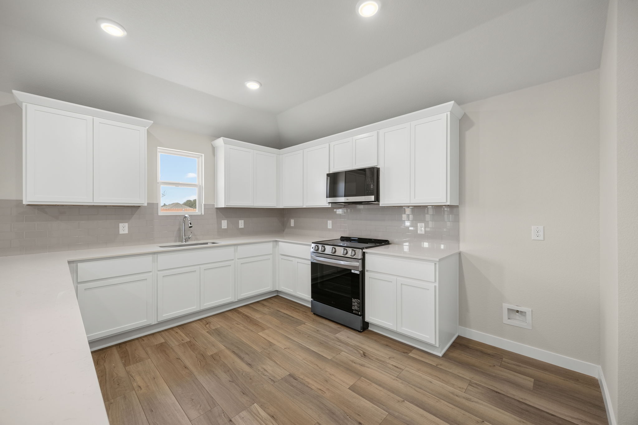 A kitchen with white cabinets.