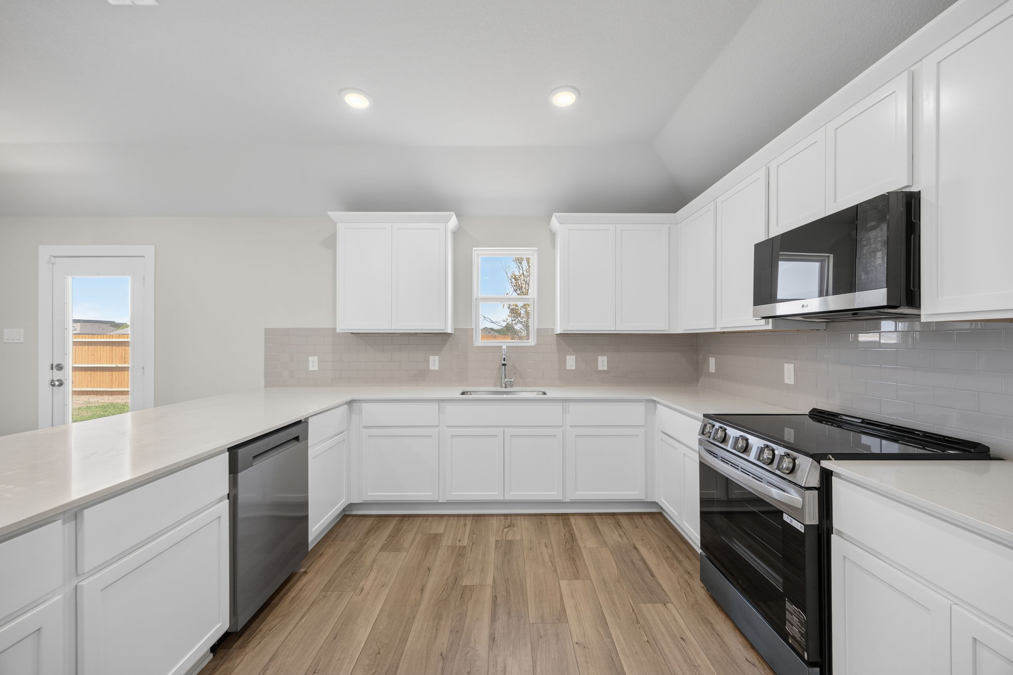 A kitchen with white cabinets.