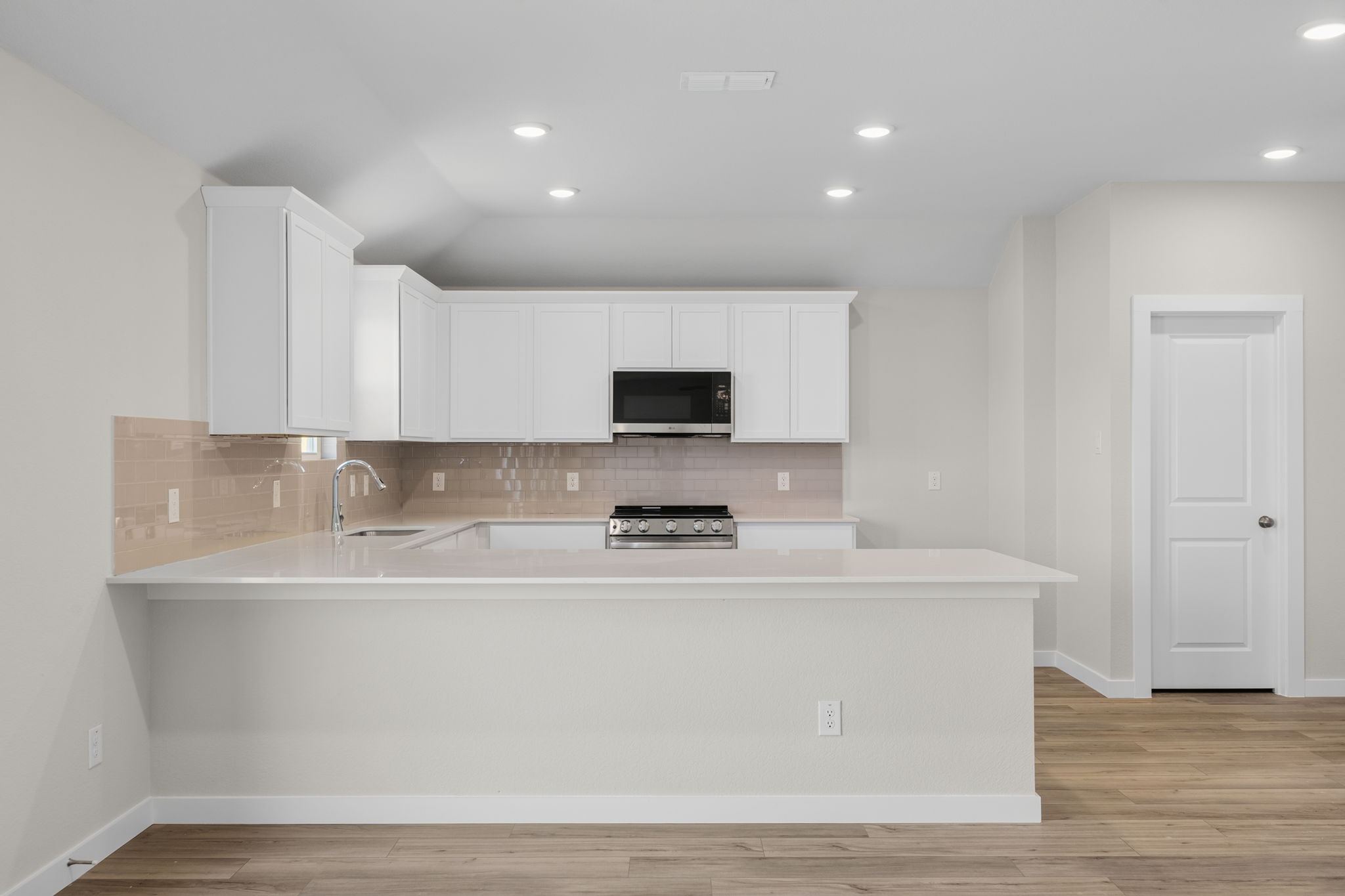 A kitchen with white cabinets.