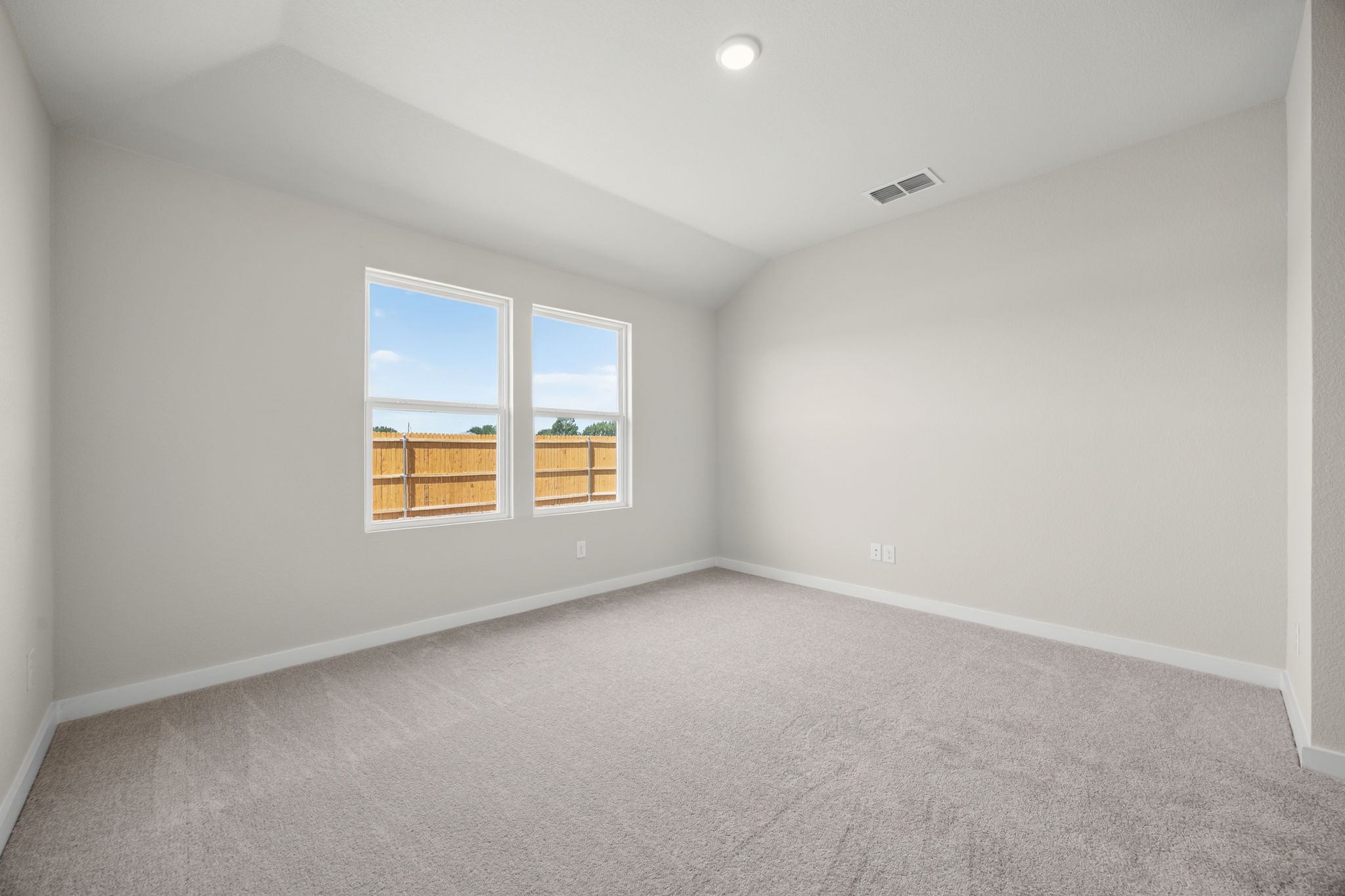 A room with a window and a carpet.