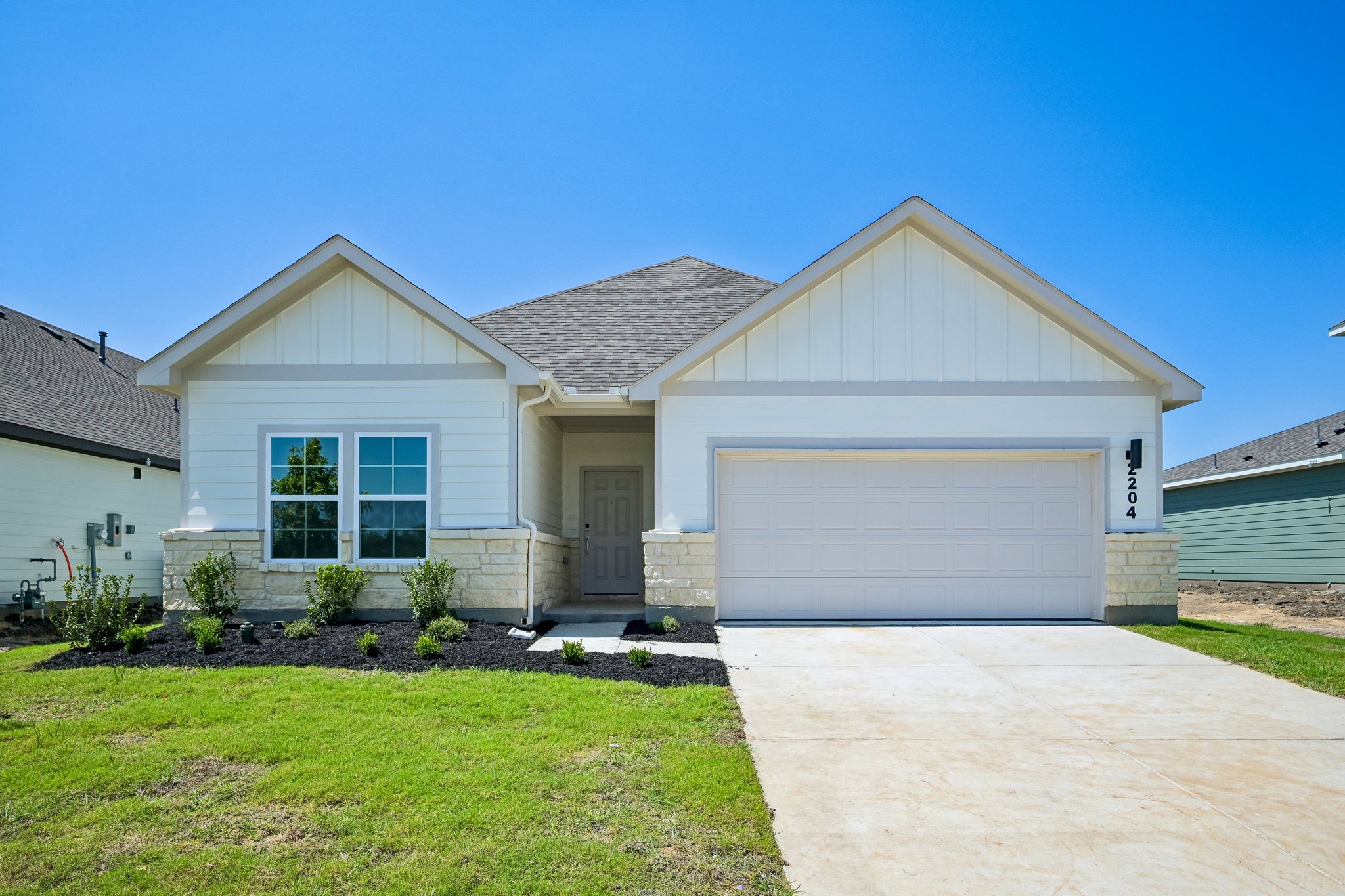 A house with a garage with Southfork Ranch in the background.