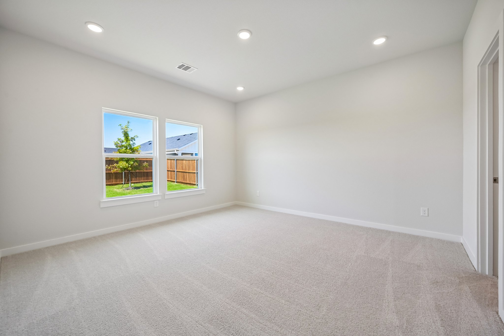 A room with a window and a tree.